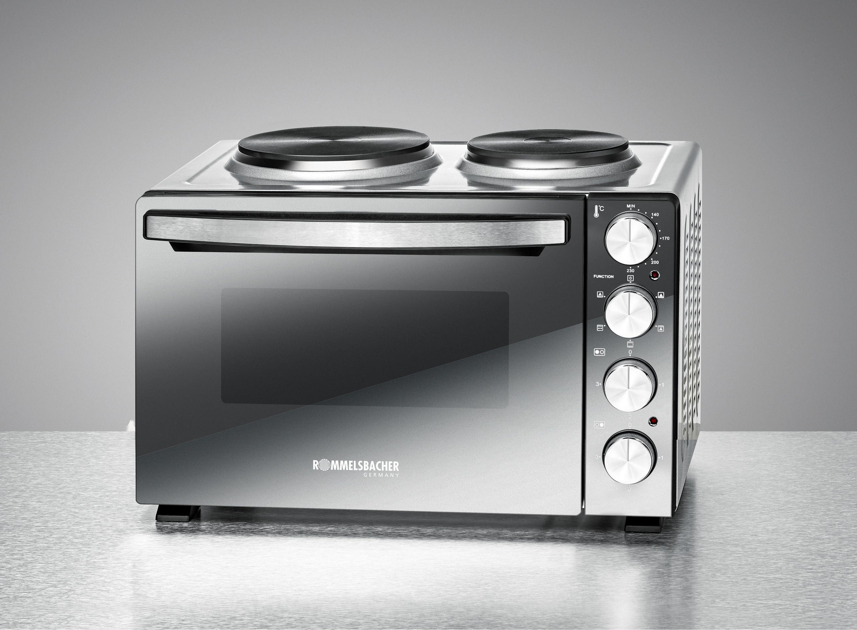 Un forno in acciaio inox con porta a vetro, due fornelli e tre manopole di controllo. Su un tavolo.