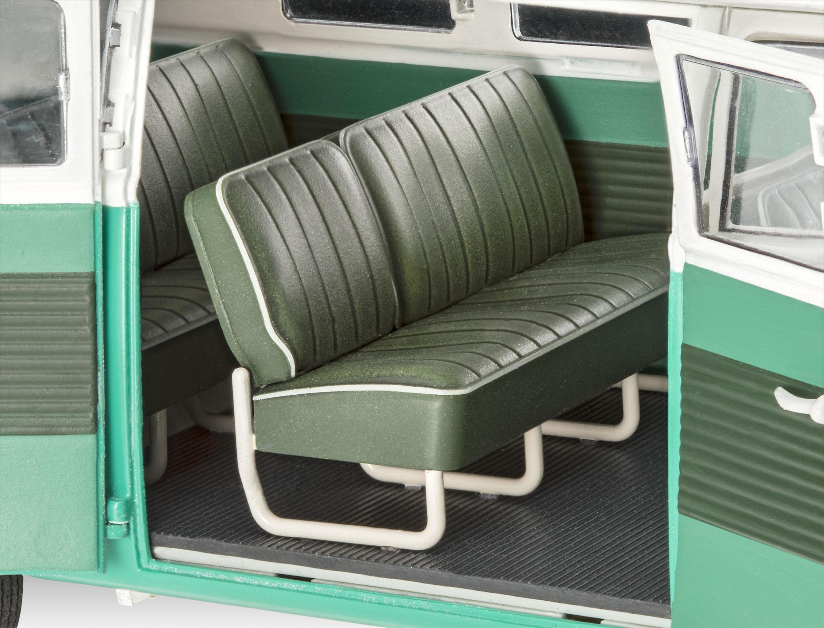 Im Inneren eines grün-weißen VW-Busses mit zwei grünen Sitzen und dunklem Boden.
