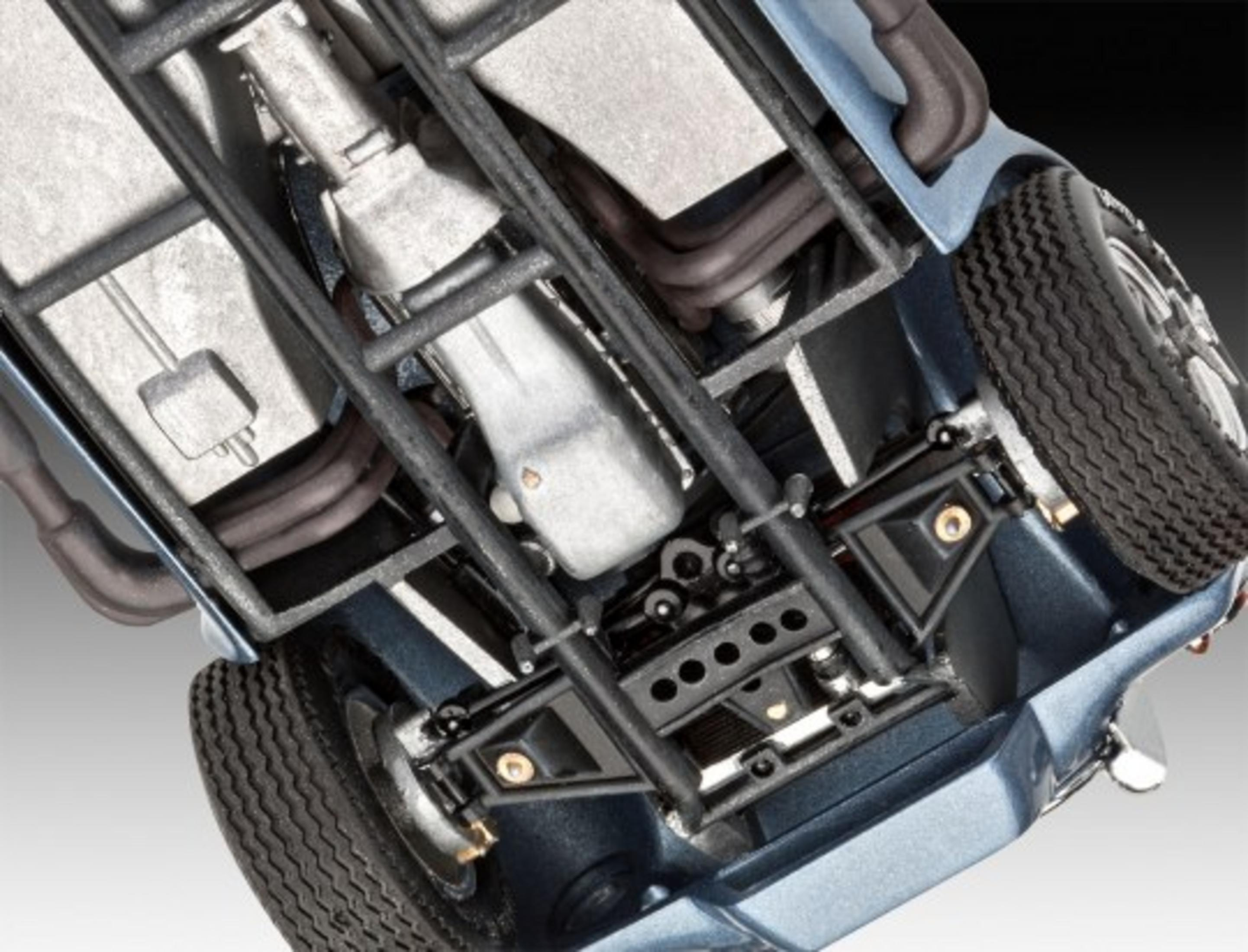 Unterseite eines blauen Modellautos, das Fahrgestell, Räder und Motordetails zeigt.