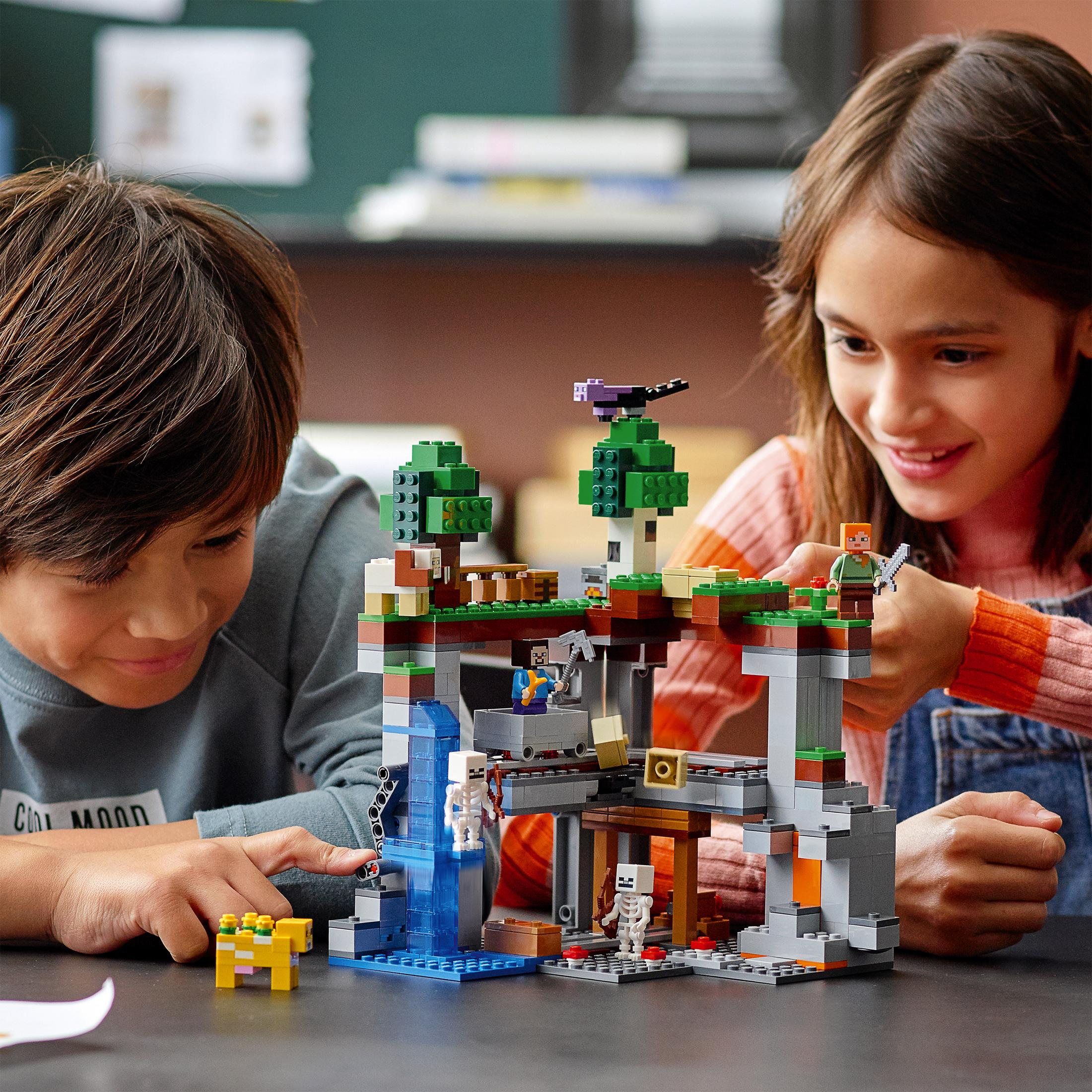 Due bambini che costruiscono un set Lego Minecraft con blocchi e personaggi.