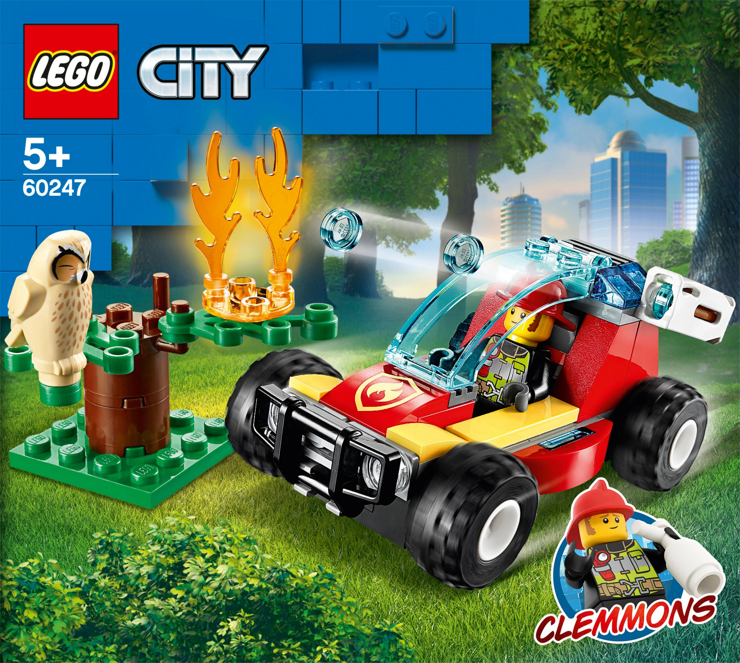 Ein LEGO City Feuerwehrauto-Spielzeug mit einer kleinen Eule, einem Baumstumpf und einer Stadtkulisse im Hintergrund.