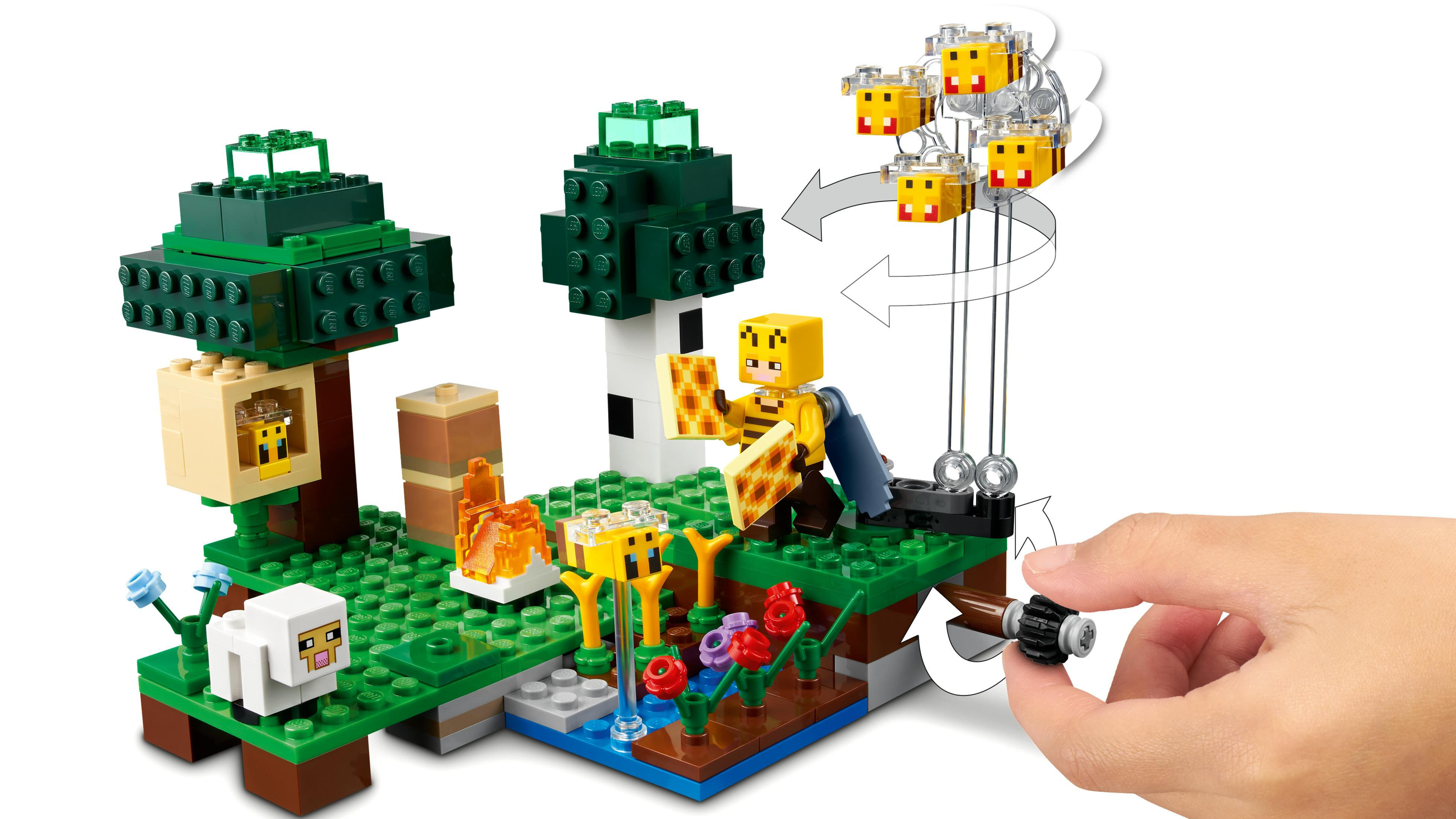 Lego-Set mit einer Minecraft-Szene. Eine Hand dreht einen Knopf, um Bienen in der Szene fliegen zu lassen.