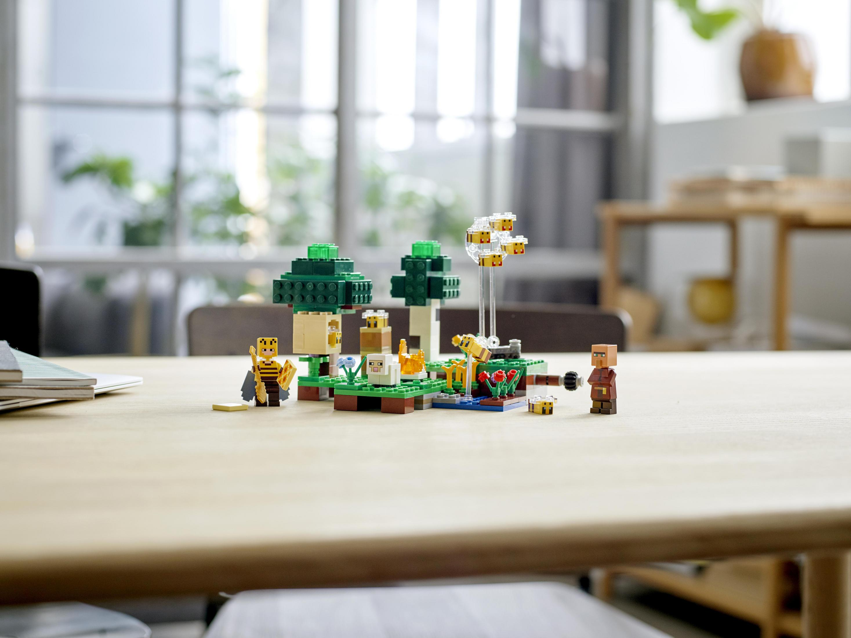 Lego Minecraft Set auf einem Tisch. Enthält Bäume, Bienen, einen Dorfbewohner und Tiere. Verschwommener Hintergrund.