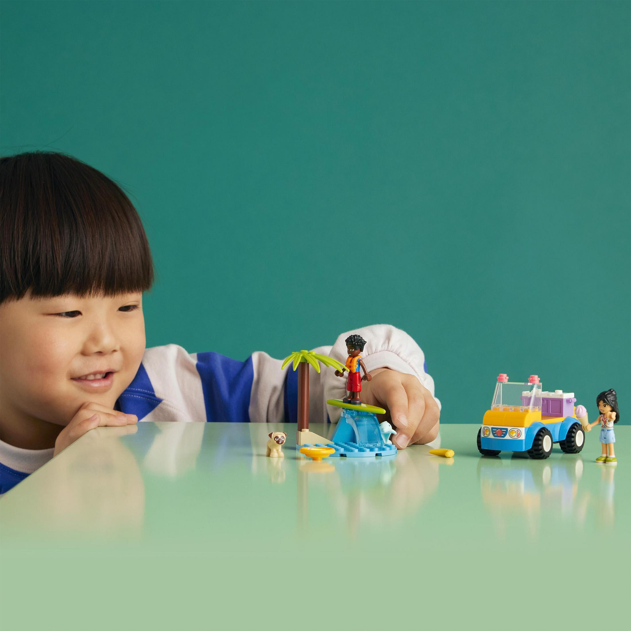Een kind bekijkt een LEGO-set met speelfiguren en een kleine auto op een groen oppervlak. Groene achtergrond.