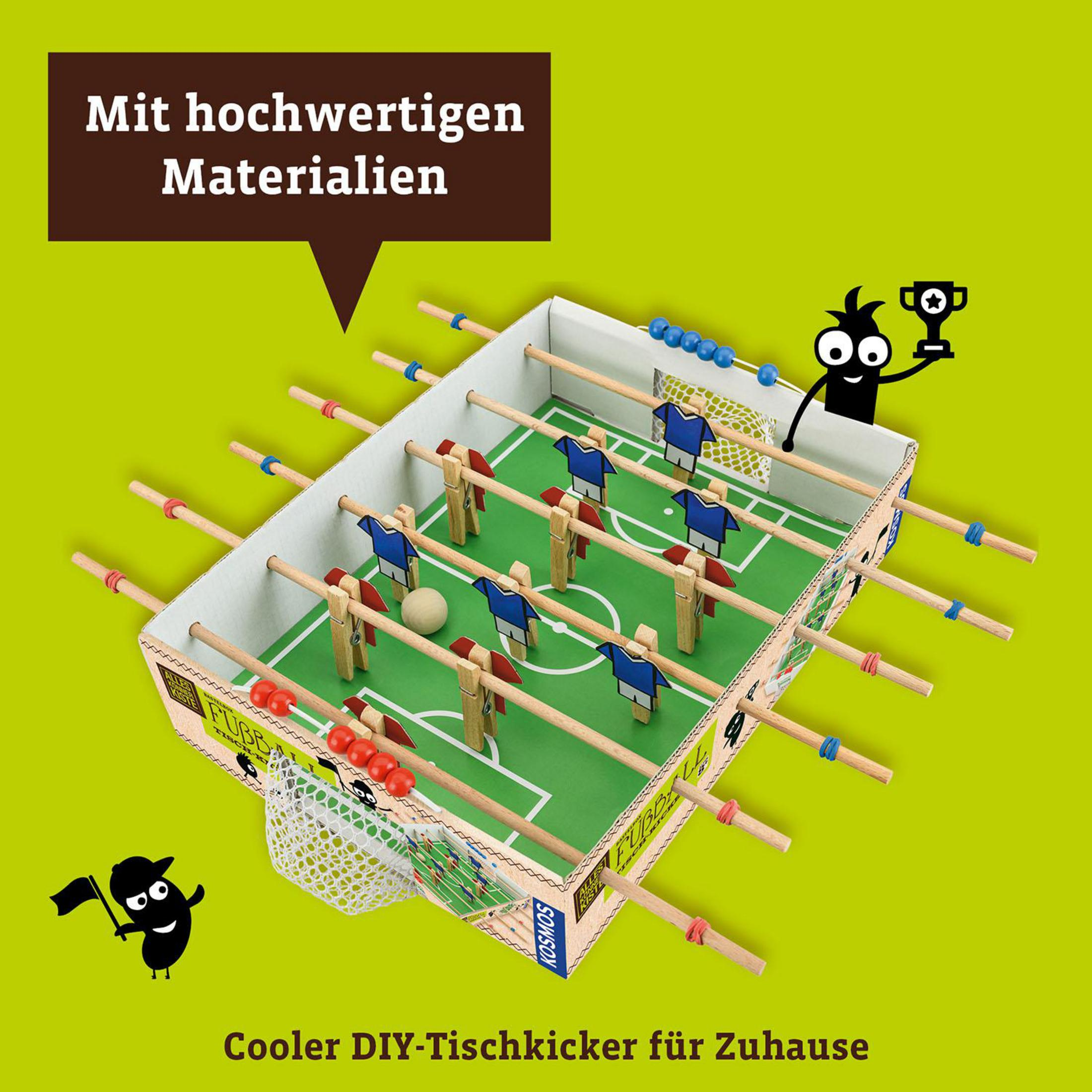 Ein DIY-Tischfußball mit Holzspielern und einem grünen Feld, mit einer jubelnden Cartoonfigur.