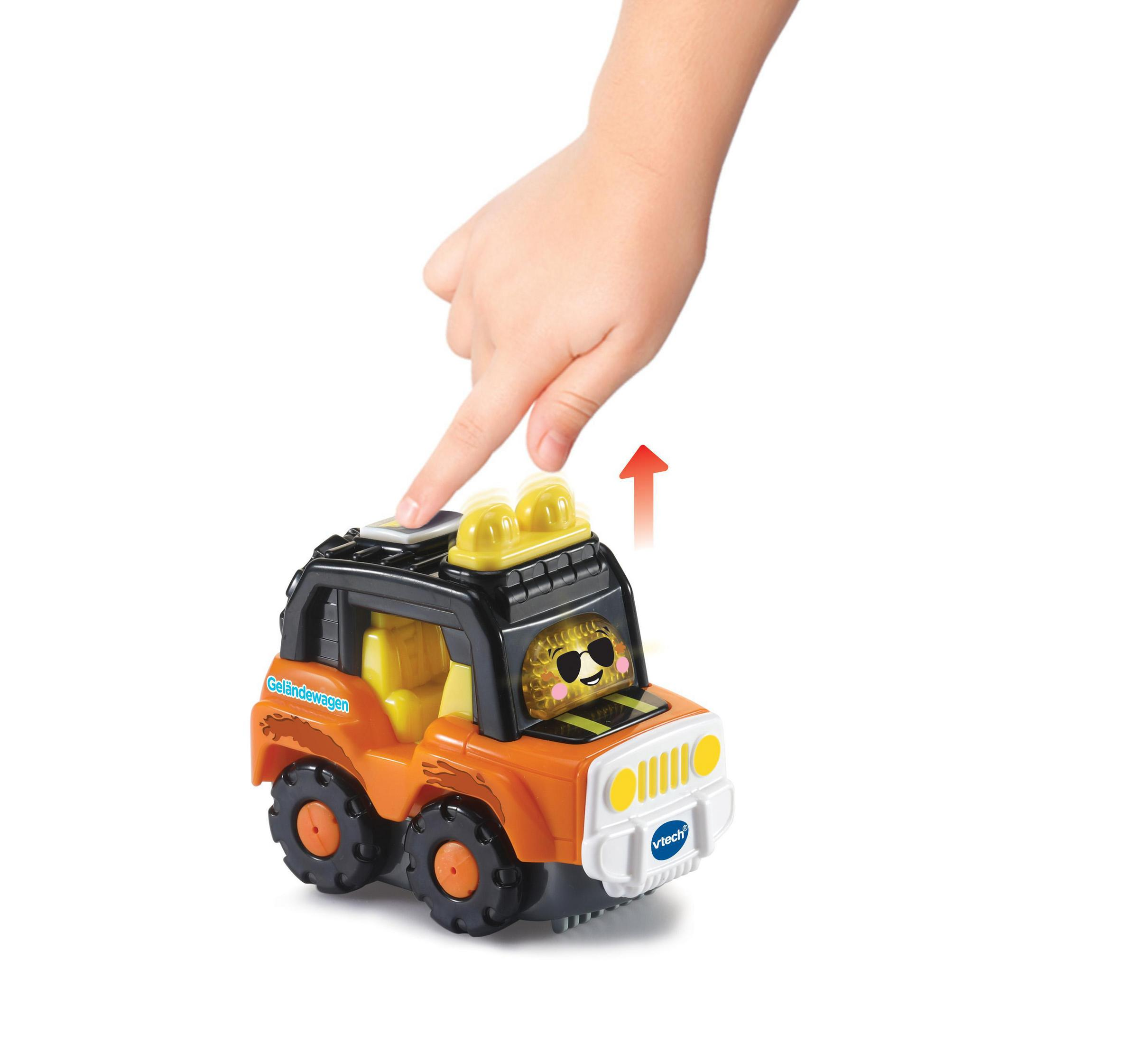 Die Hand eines Kindes, die einen Knopf auf einem orangefarbenen Spielzeug-Jeep drückt.
