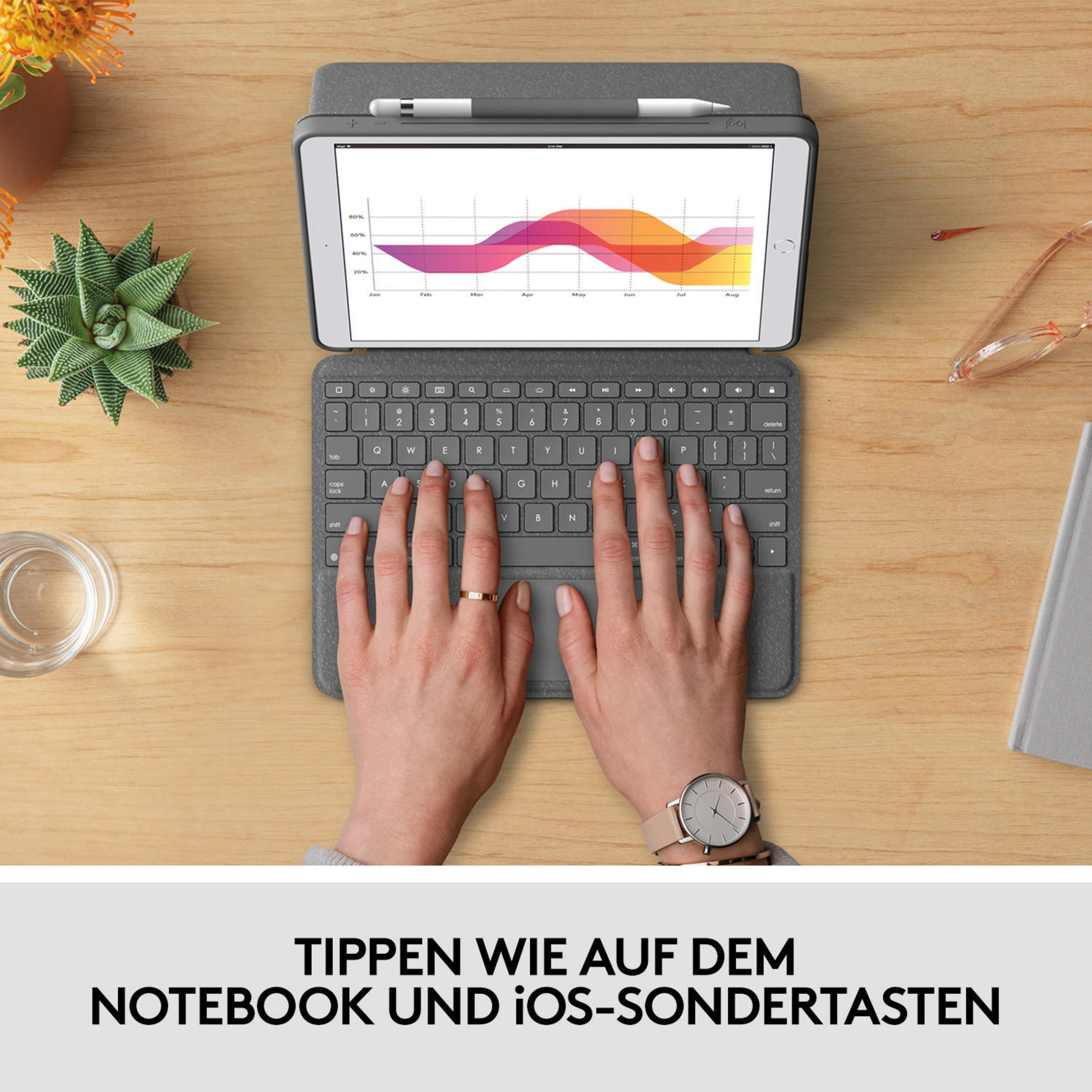 Hände tippen auf einer grauen Tastatur, die mit einem iPad verbunden ist, das ein Diagramm anzeigt, auf einem Holztisch.