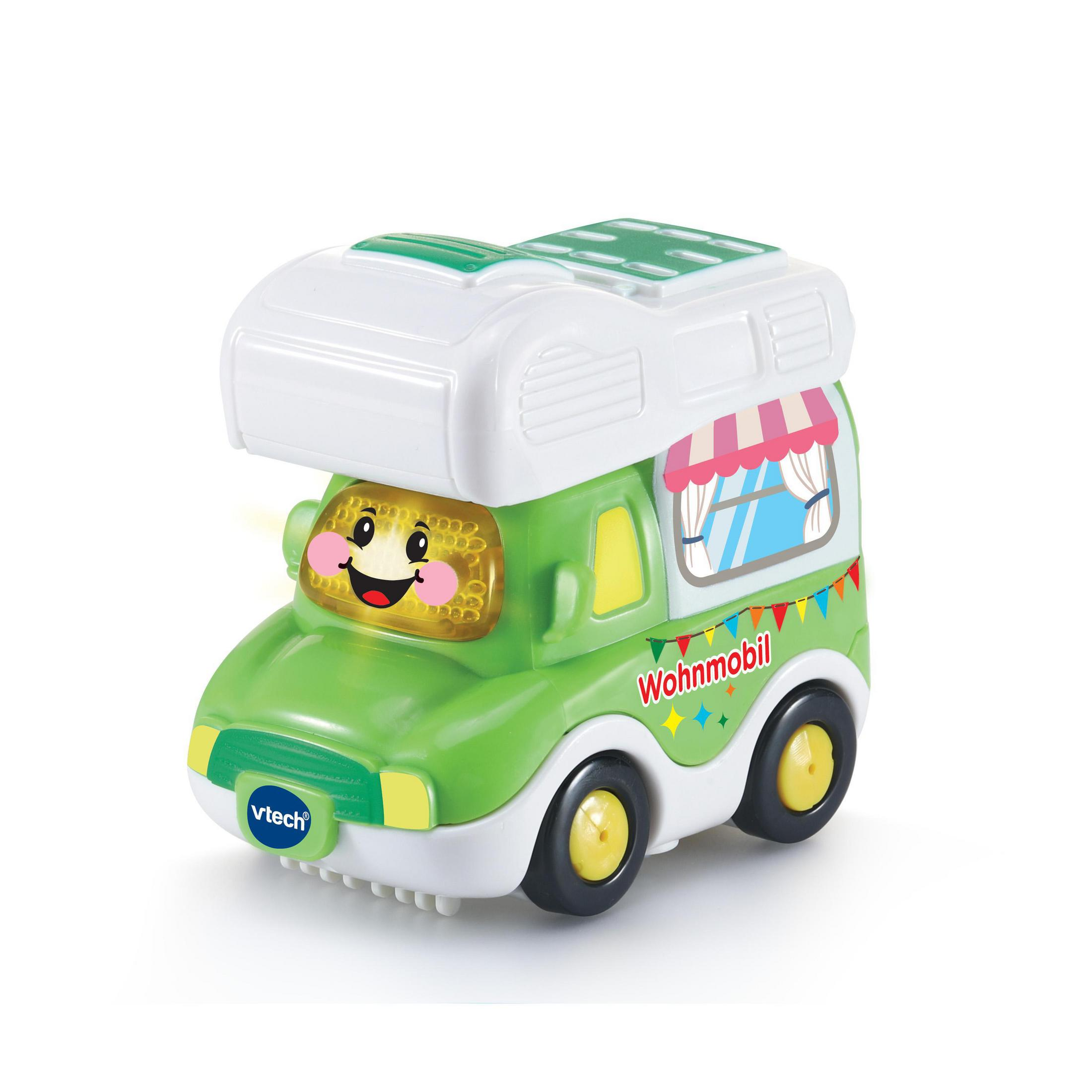 Ein grüner Spielzeug-Wohnmobil mit einem lächelnden Gesicht, Flaggen und einem weißen Dach.