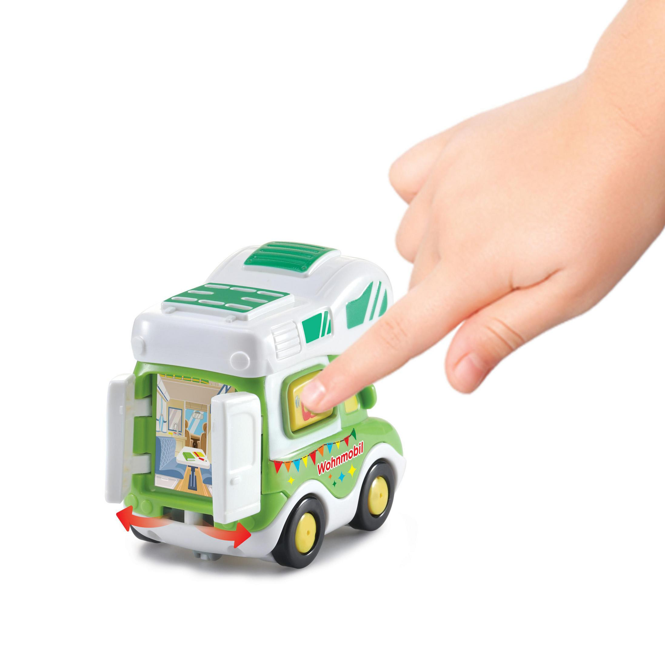 Spielzeug: Die Hand eines Kindes öffnet ein grün-weißes Wohnmobil-Spielzeug.