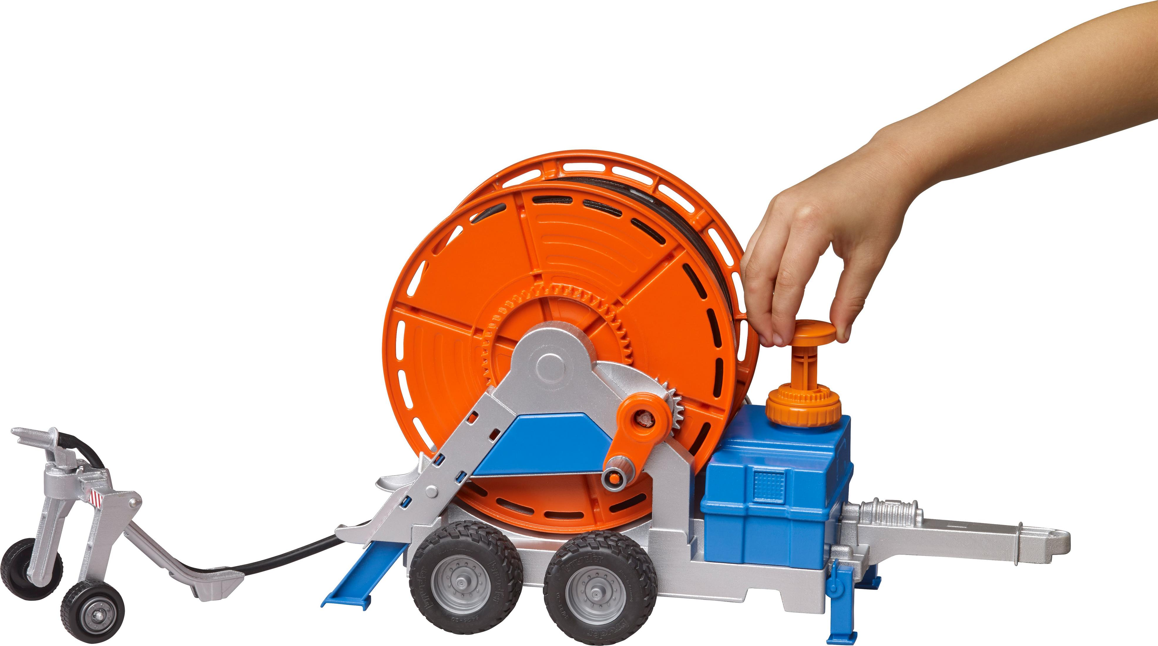 Spielzeug-Baufahrzeug mit orangefarbener Rolle, blauen Details, Hand dreht Knauf. Weißer Hintergrund.