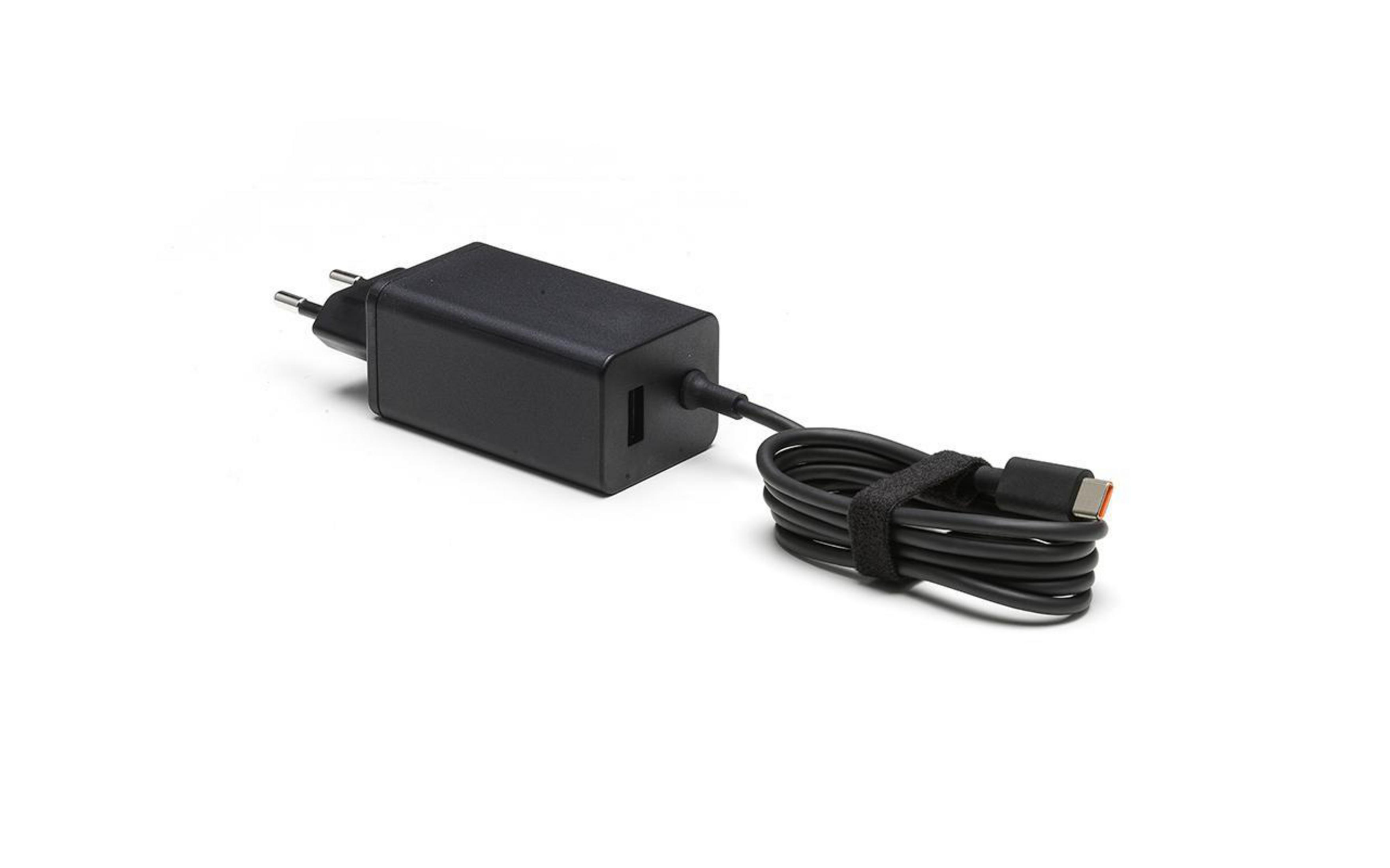 Un caricabatterie per laptop nero con cavo USB-C. Il caricabatterie è su una superficie bianca.