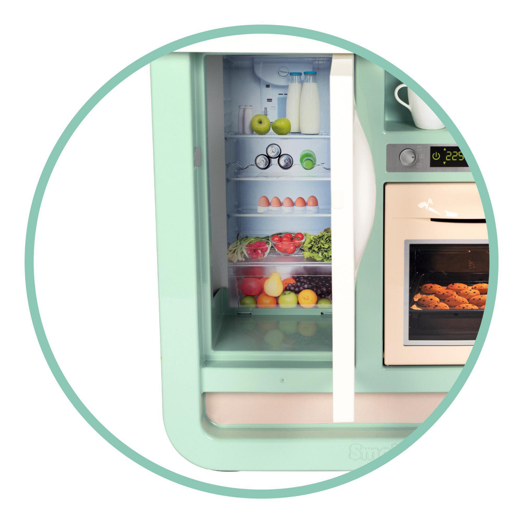 Spielzeug-Kühlschrank mit Essen. Enthält Obst, Eier und Milch. Grün und Weiß.