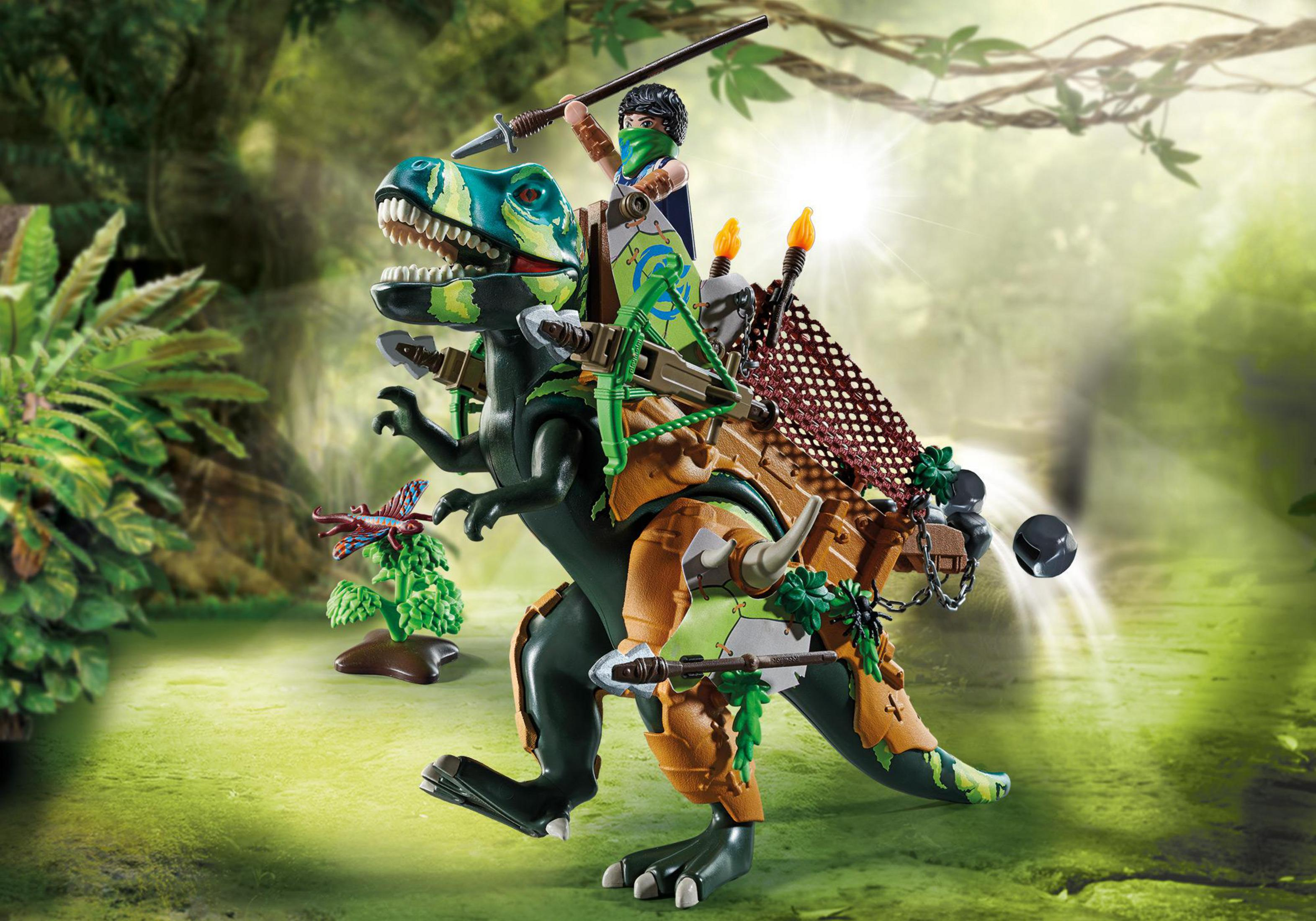 Un giocattolo di dinosauro verde e blu cavalcato da una figura Playmobil in una scena della giungla.