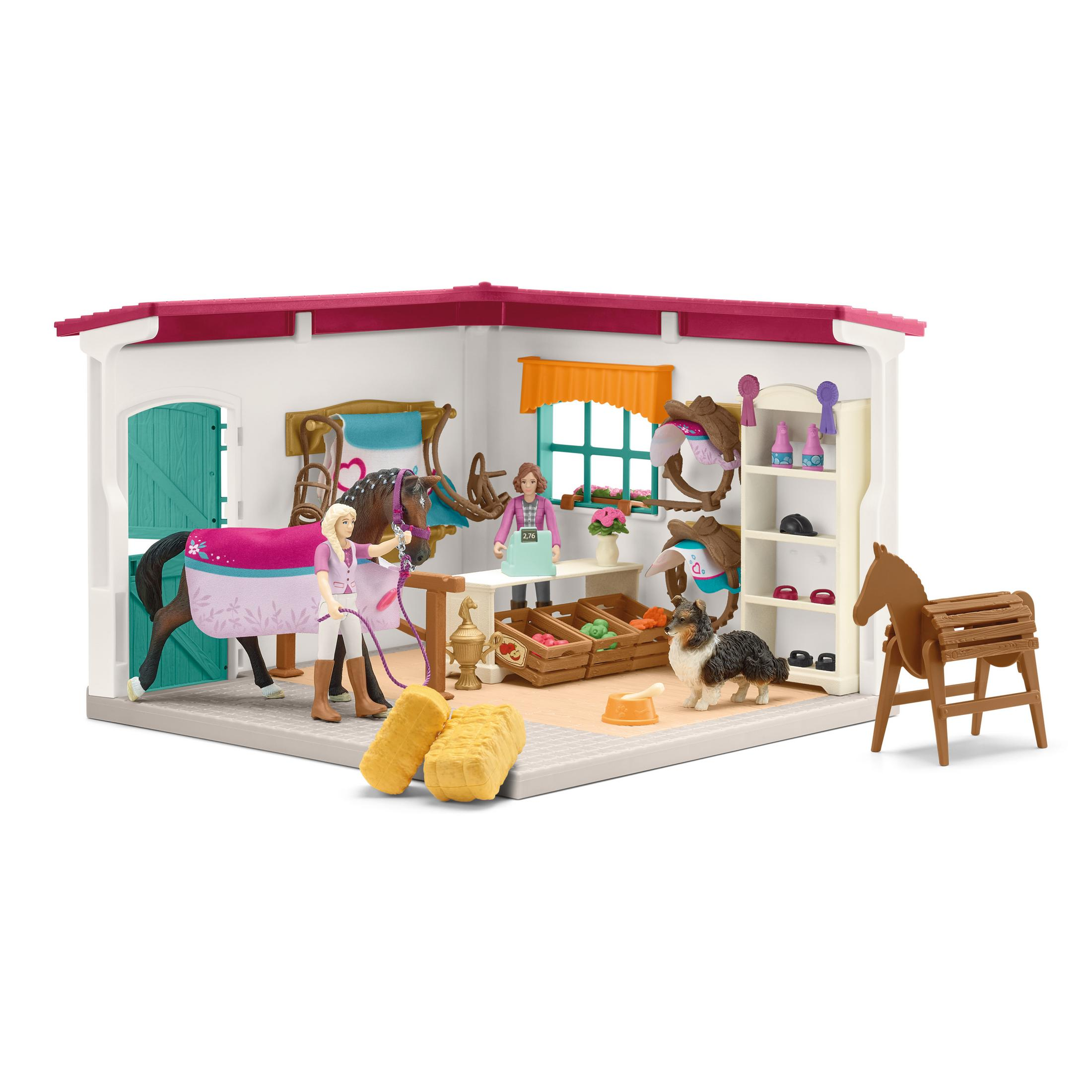 Ein Pferdestall-Spielset mit Figuren, einem Pferd und Zubehör auf weißer Oberfläche.