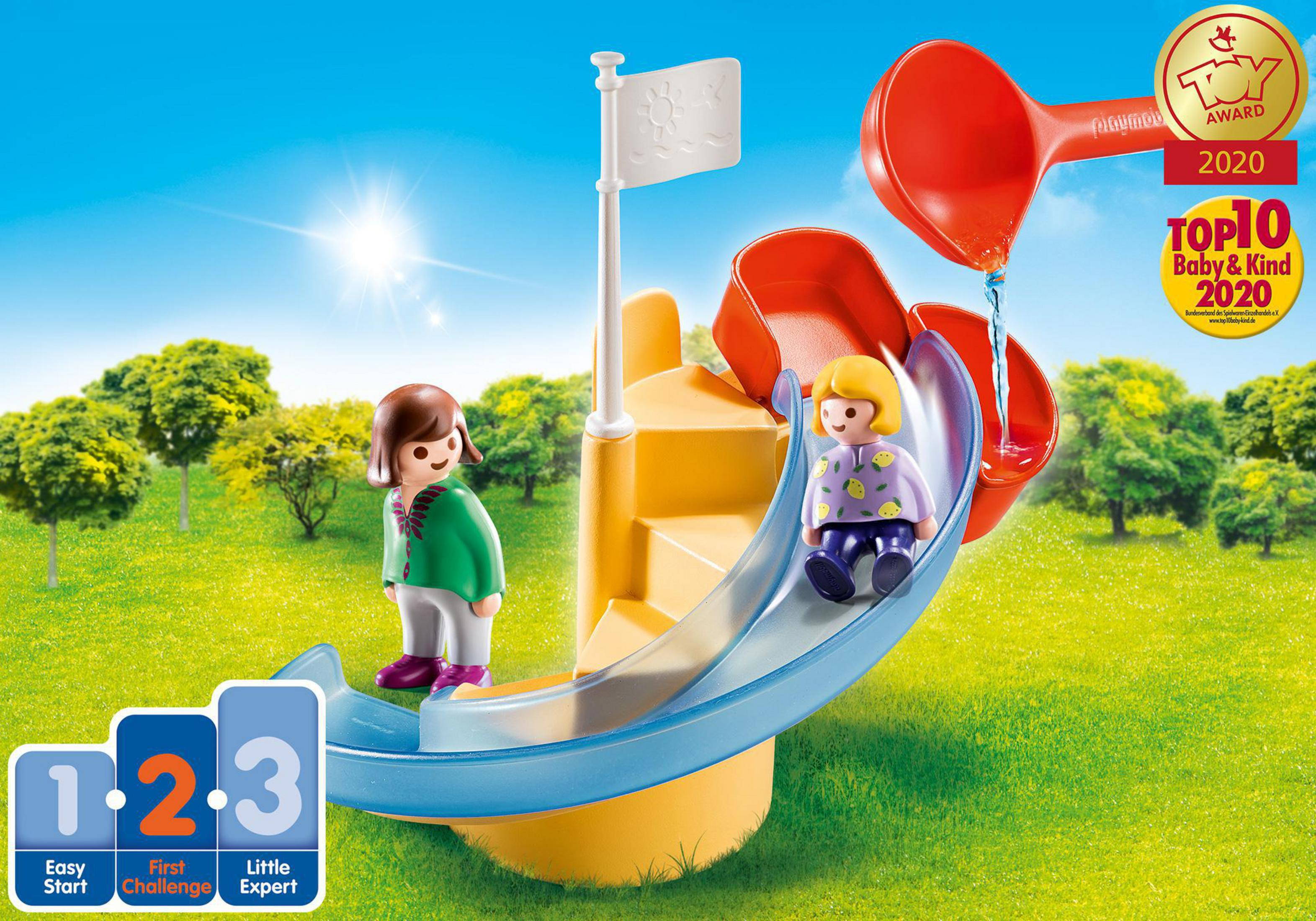 Playmobil-Spielset mit Rutsche und zwei Figuren. Der Hintergrund ist ein sonniger Park.