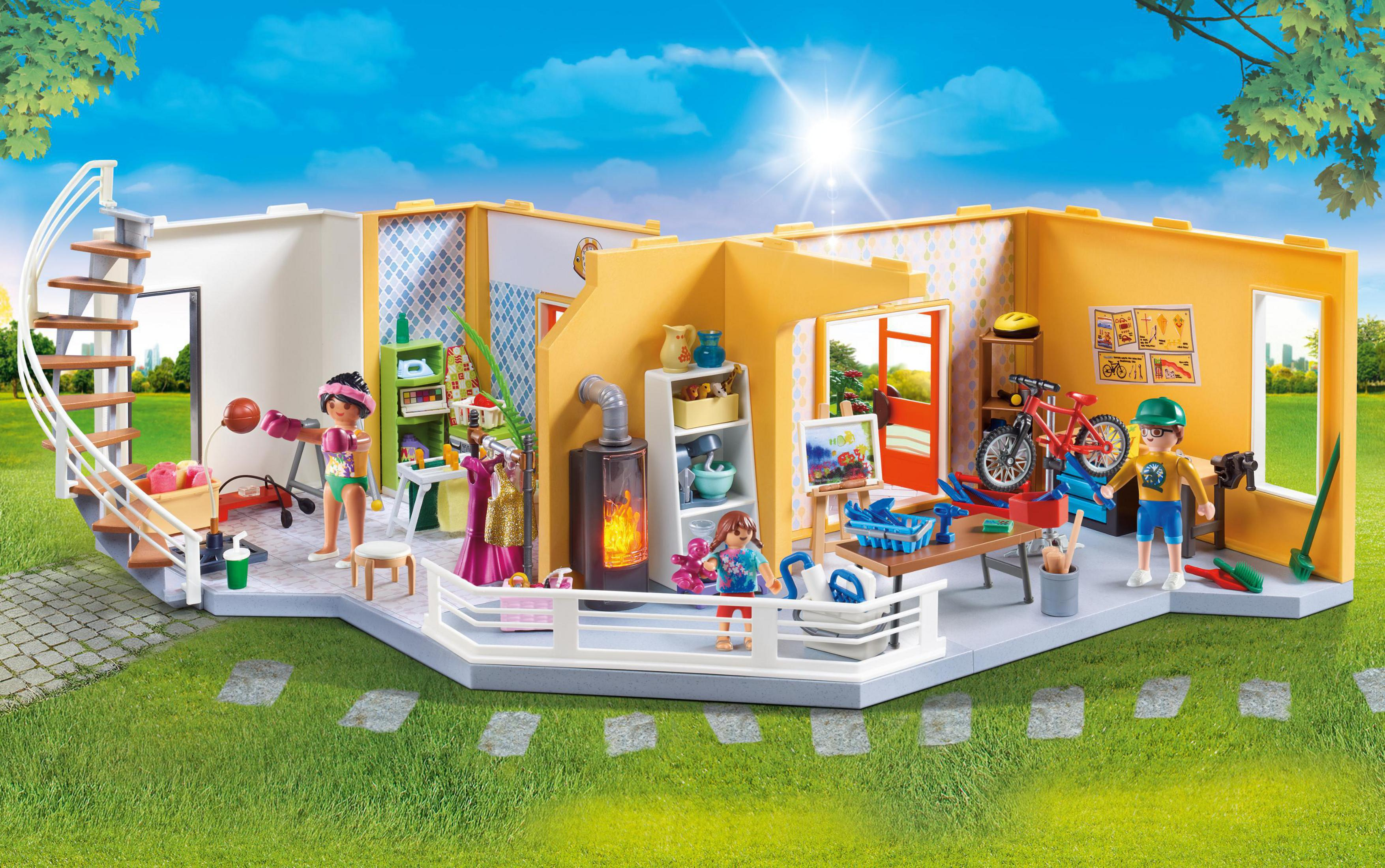 Playmobil-Haus-Set mit Figuren und Zubehör, Innen- und Außenszenen, sonniger Hintergrund.