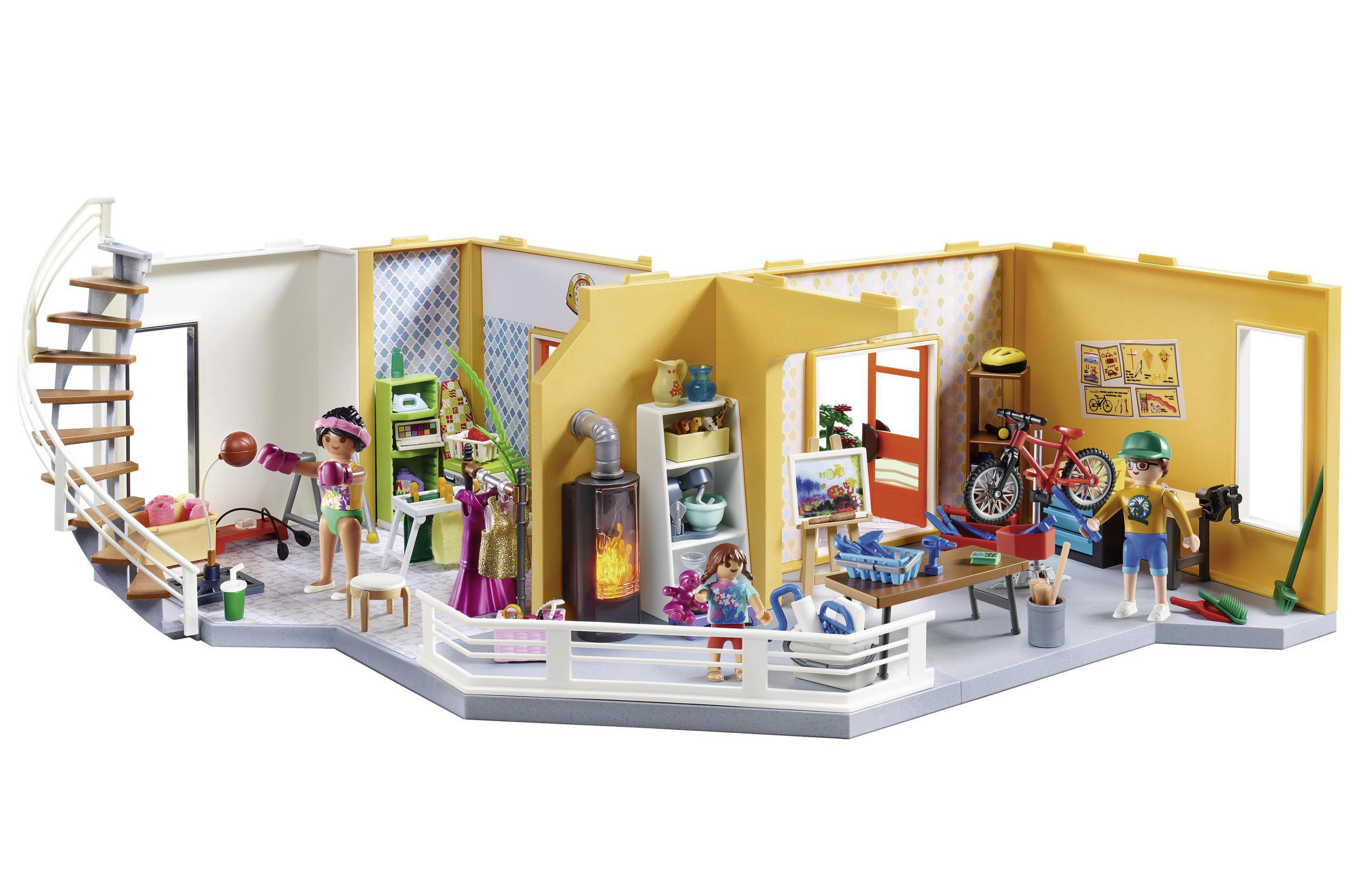 Ein Playmobil-Puppenhaus wird gezeigt, mit mehreren Räumen und Playmobil-Figuren vor weißem Hintergrund.