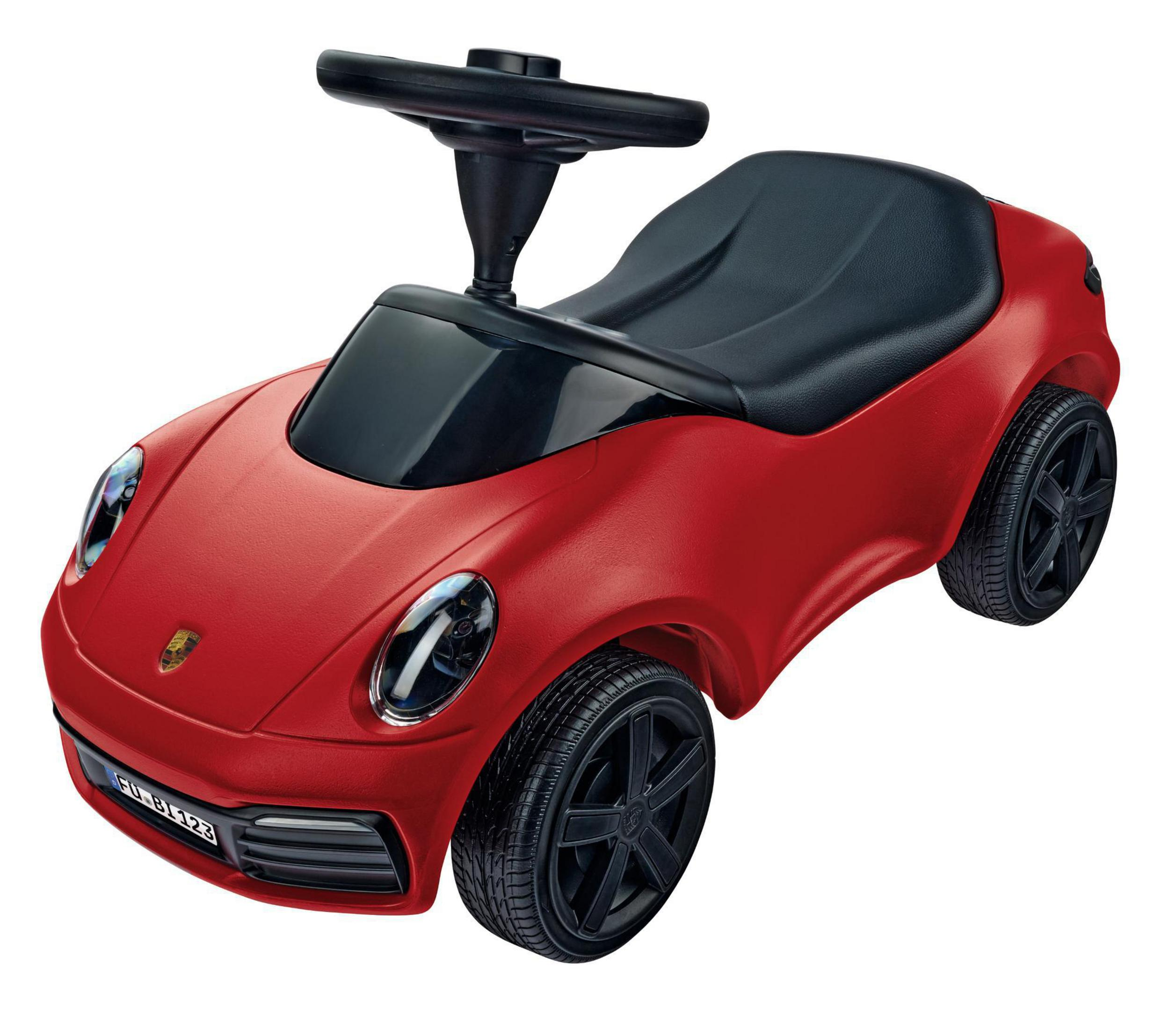 Rotes Spielzeugauto mit schwarzen Rädern, einem schwarzen Sitz und einem Lenkrad. Weißer Hintergrund.
