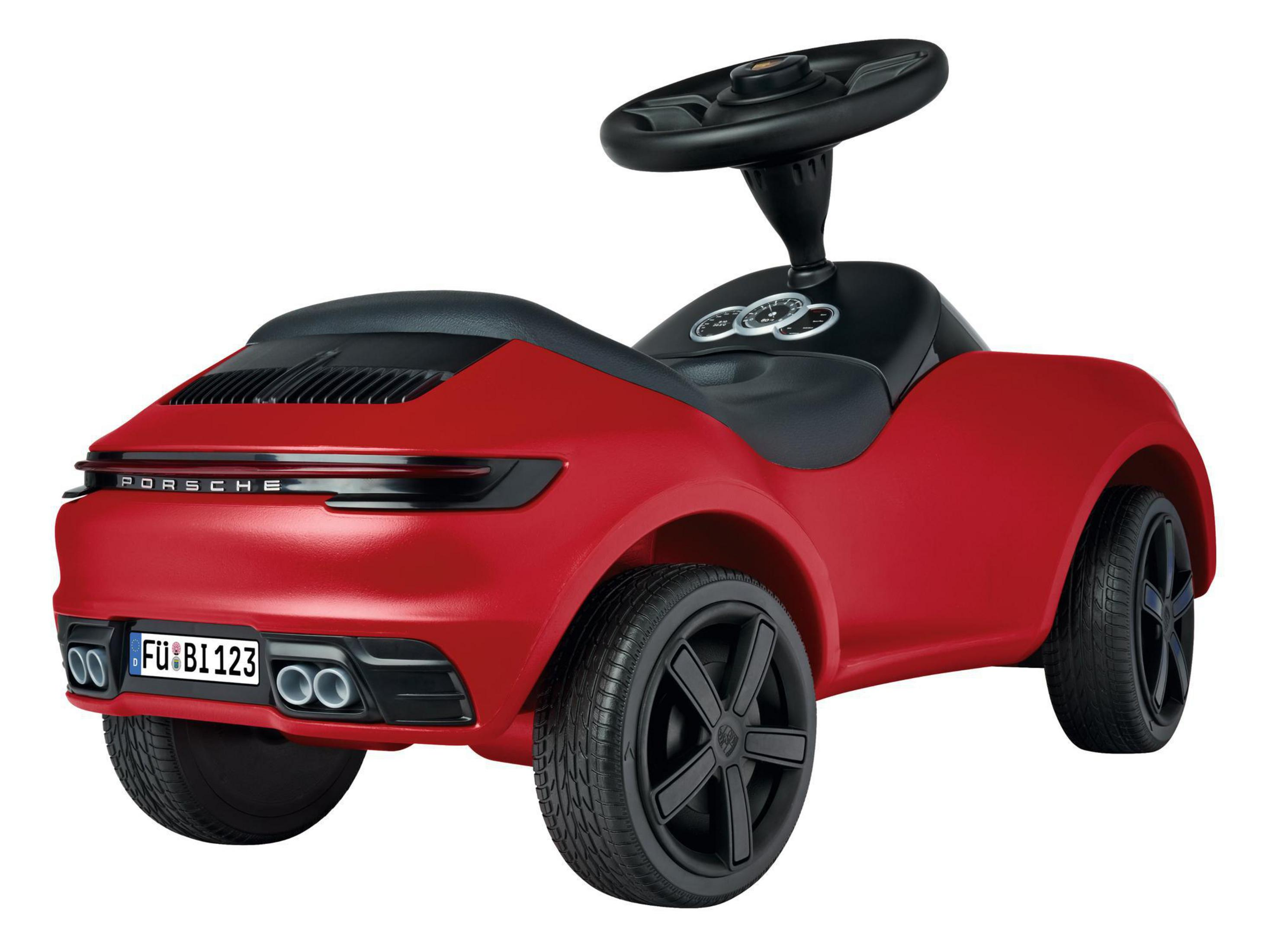 Ein rotes Spielzeugauto. Es hat schwarze Räder und ein schwarzes Lenkrad. Das Auto steht auf weißem Untergrund.