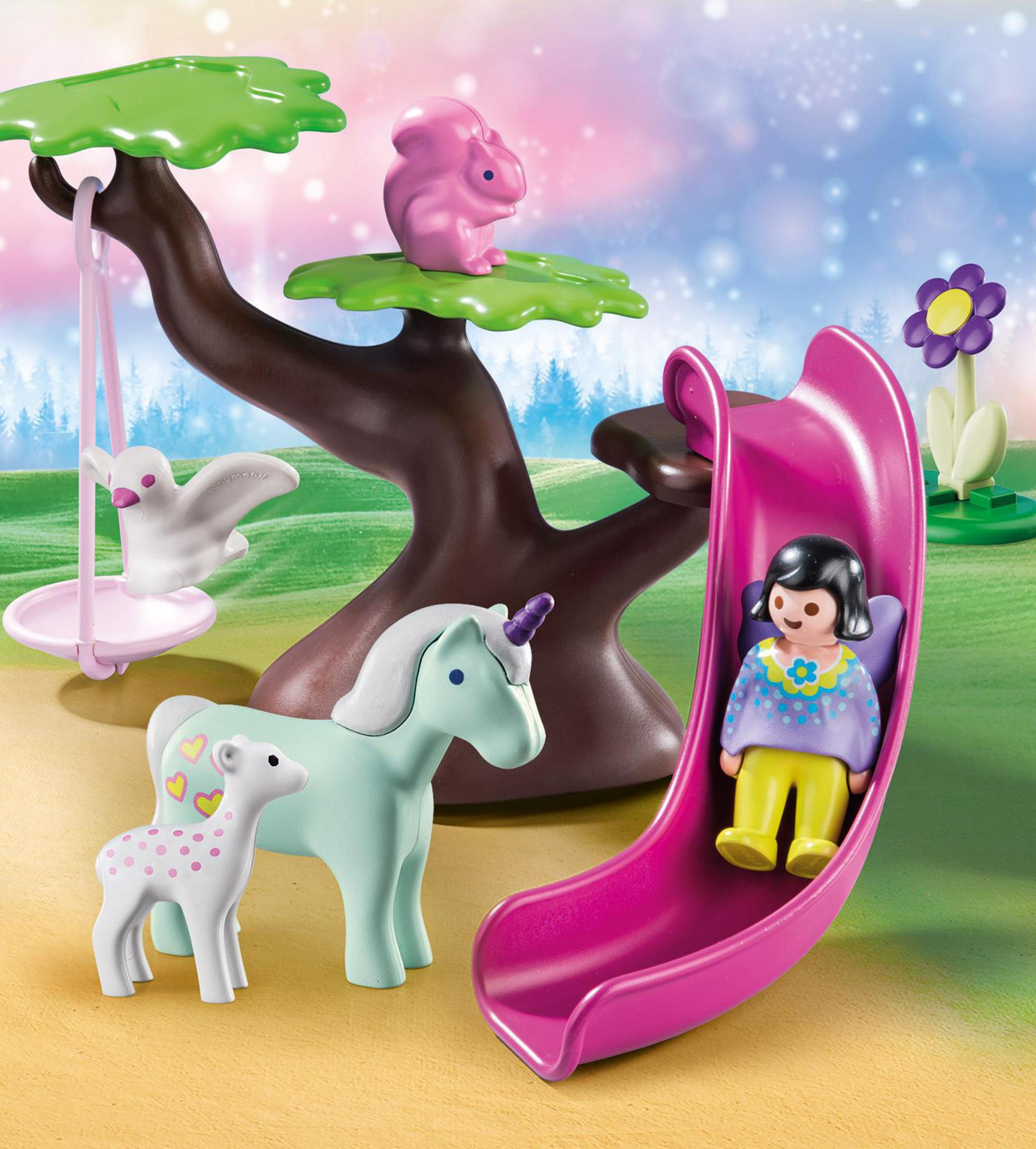 Scena Playmobil con uno scivolo, un unicorno, un albero e personaggi.