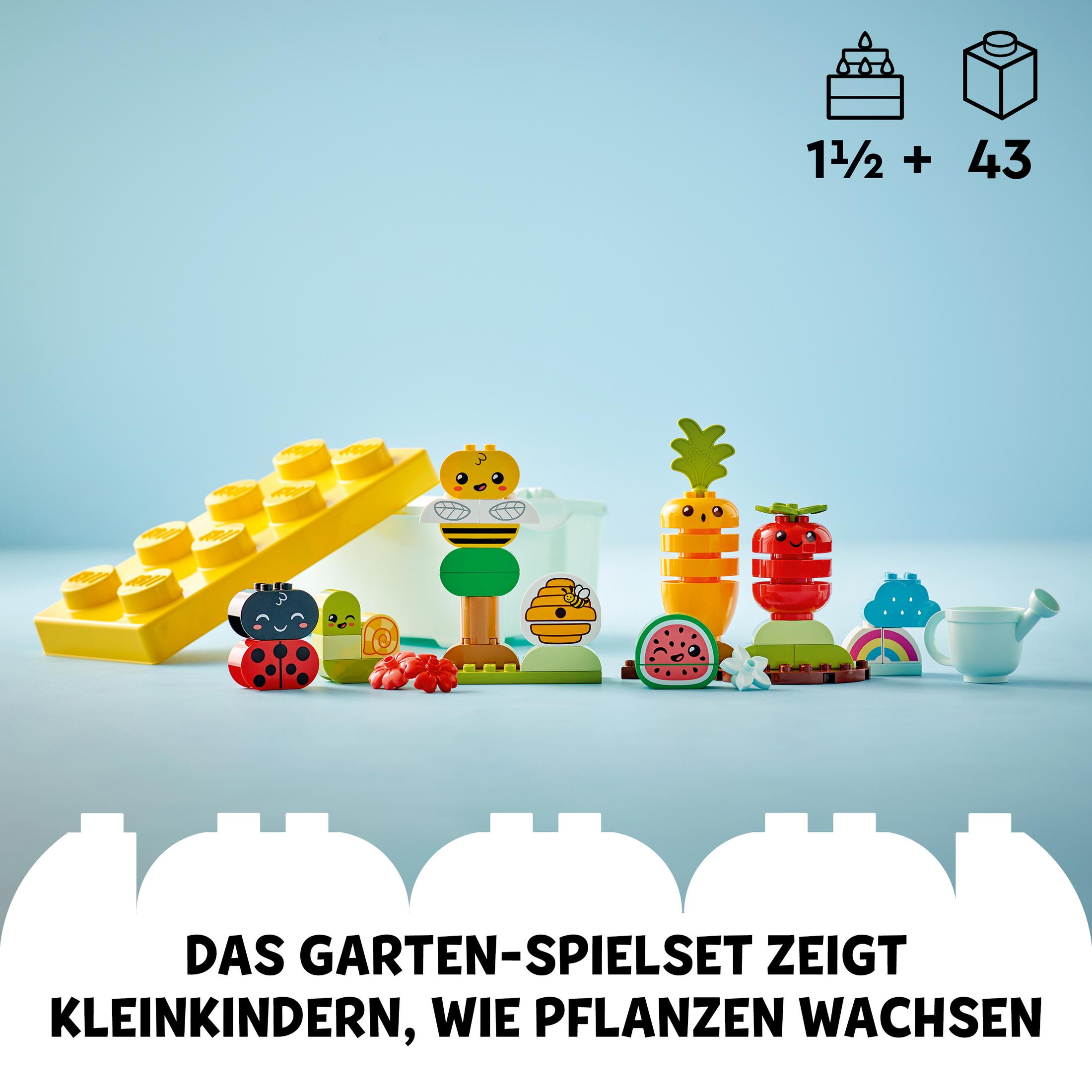 Zestaw Lego Duplo z kolorowymi elementami ogrodu, w tym pszczołą, marchewkami i konewką.