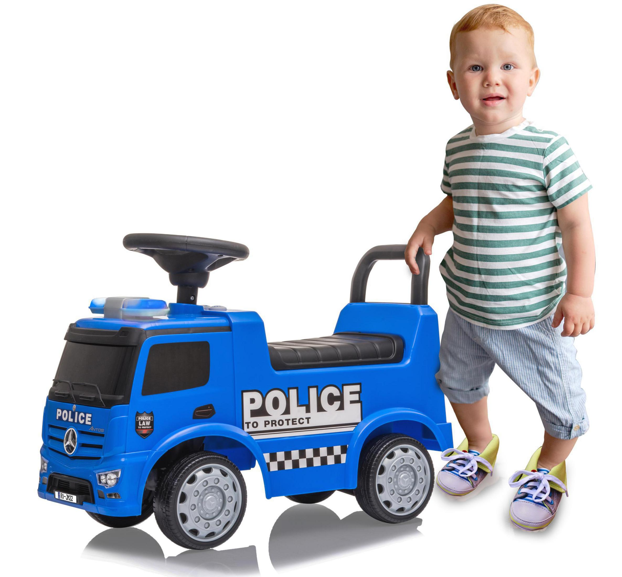 Ein Kleinkind steht neben einem blauen Spielzeug-Polizeilastwagen. Der LKW trägt die Aufschrift 'POLICE' und 'TO PROTECT'.