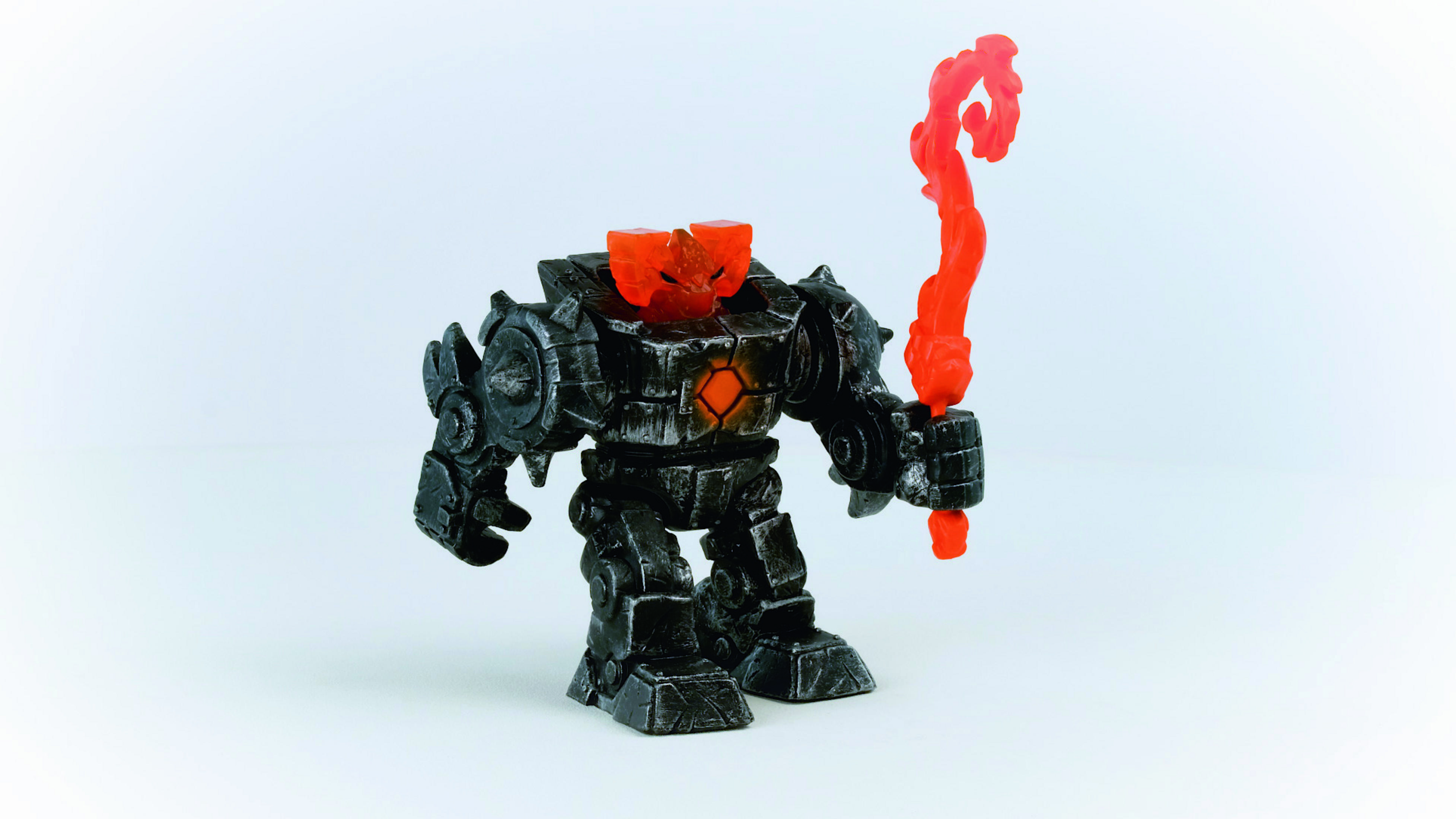 Czarny i szary zabawkowy robot trzymający płomienny pomarańczowy kij, białe tło.