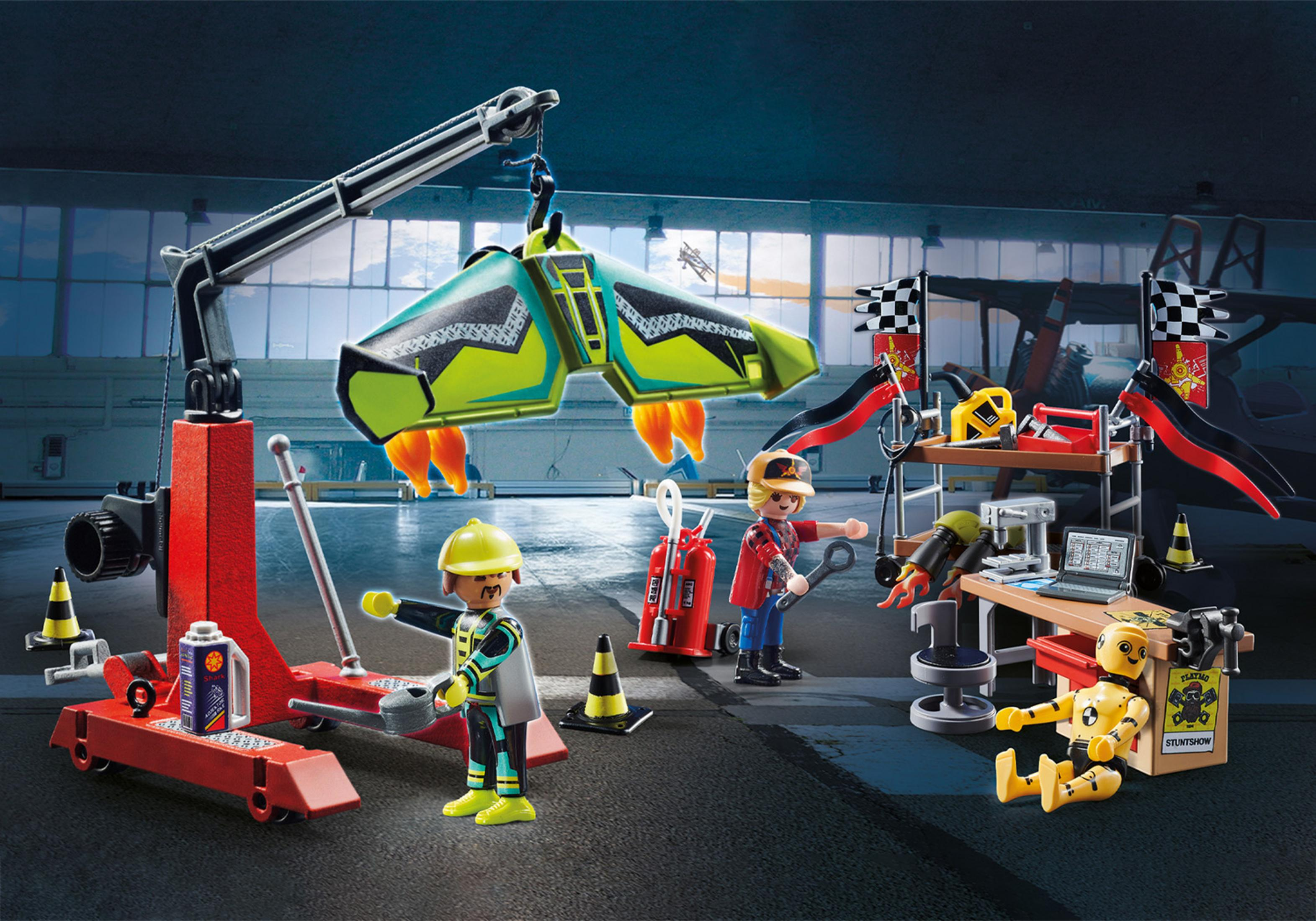 Playmobil Stunt Show Set mit Figuren, einem Kran, einem Auto und verschiedenen Bühnenelementen.