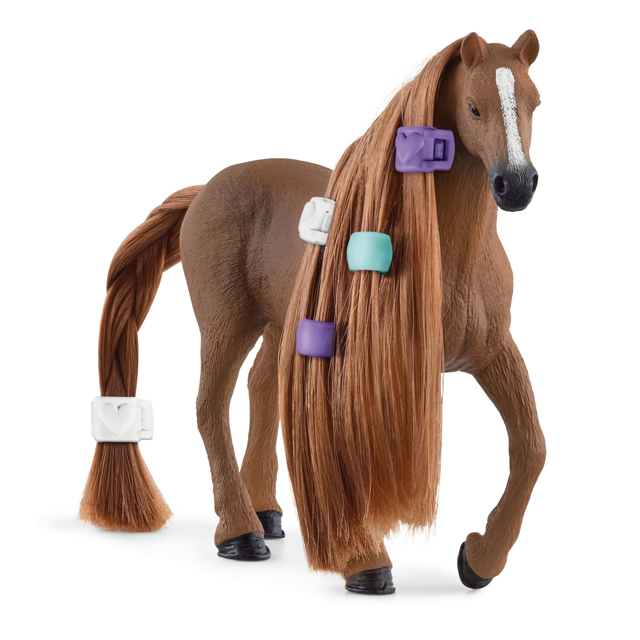 Braunes Pferd mit langem Haar, gestylt mit bunten Haaraccessoires, steht auf weißem Untergrund.