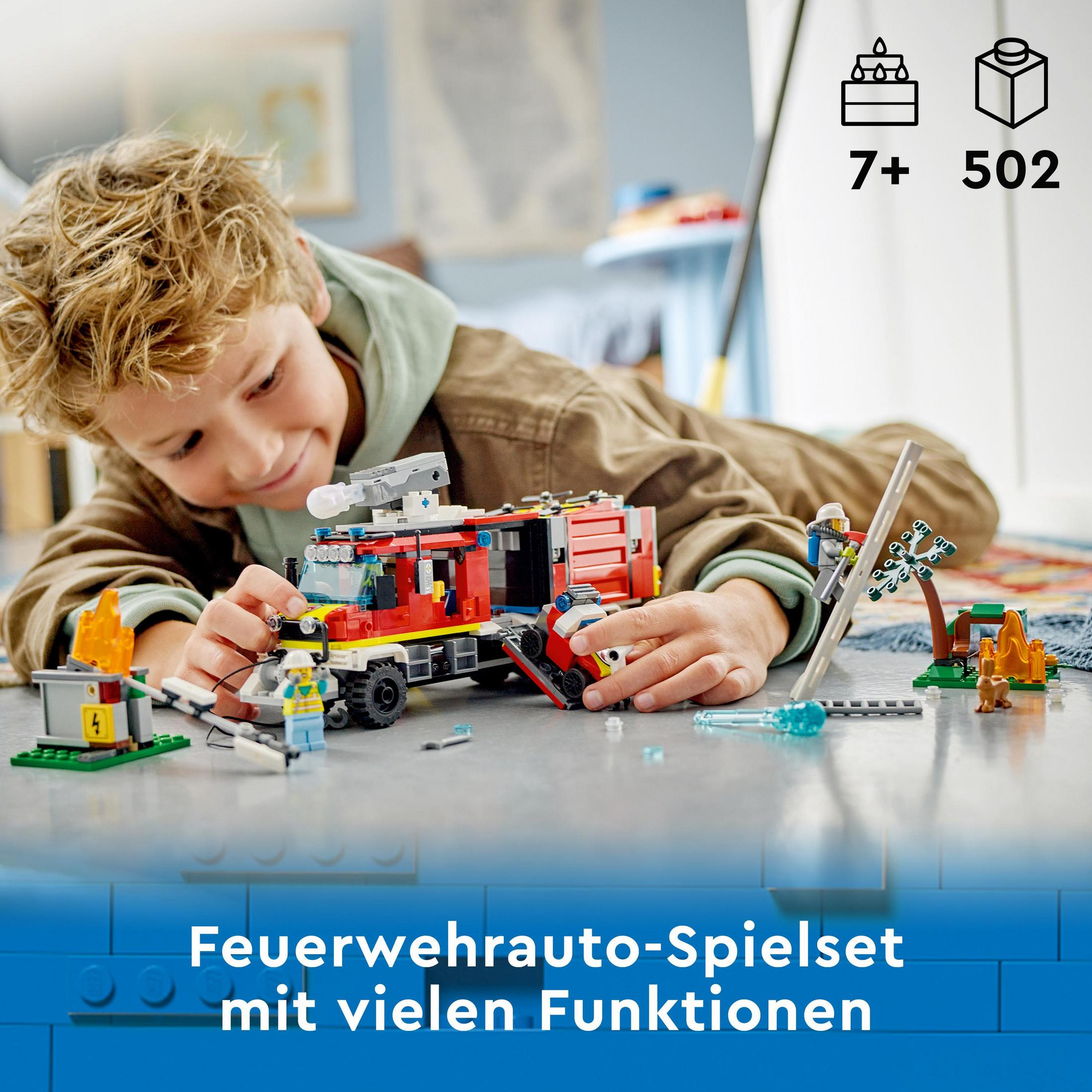 Bir çocuk Lego itfaiye kamyonu setiyle oynuyor. Set, figürler ve aksesuarlar içerir.