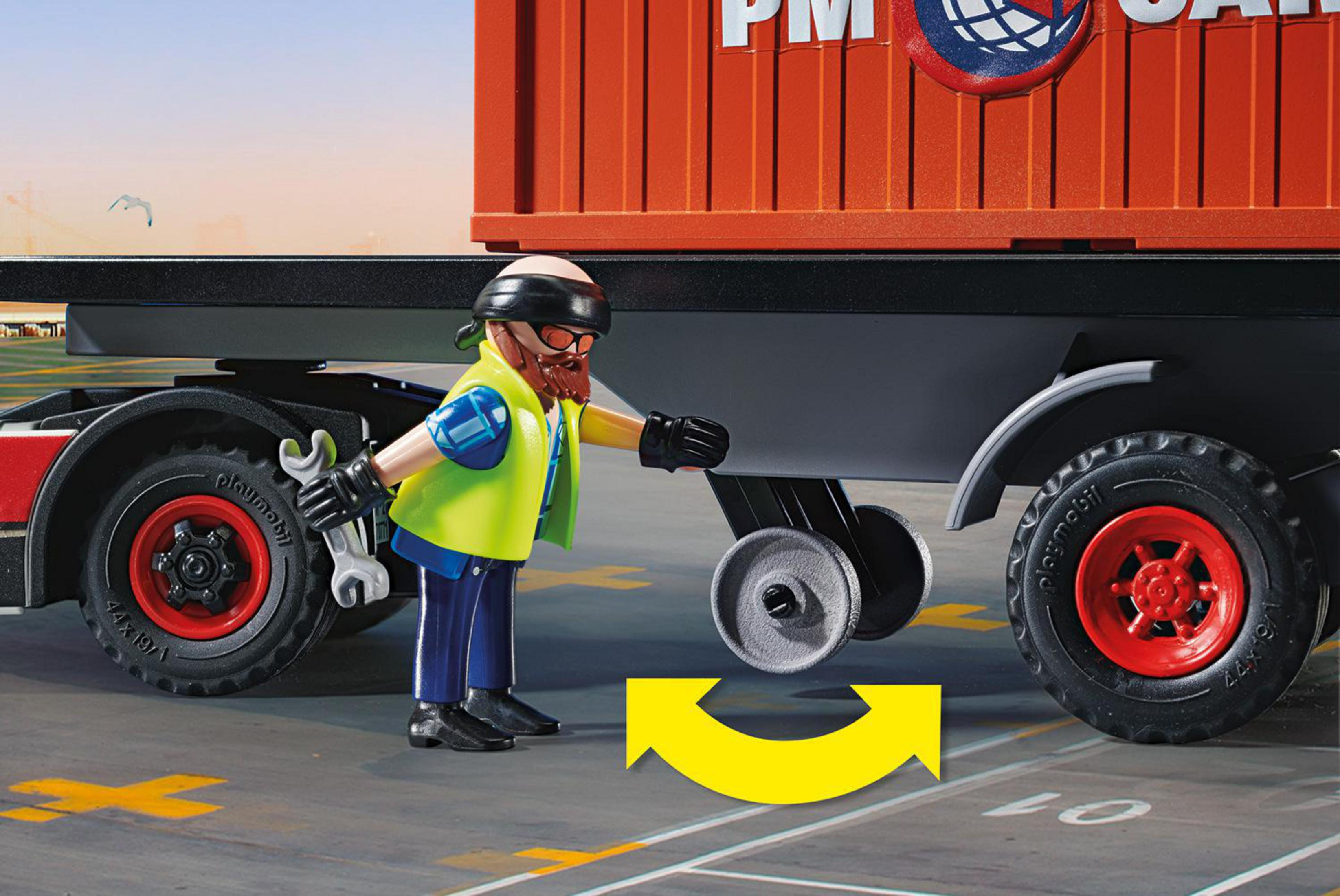 Spielzeug-LKW mit Container. Ein Arbeiter versucht, das Rad zu reparieren. Ein Pfeil zeigt die Bewegung.