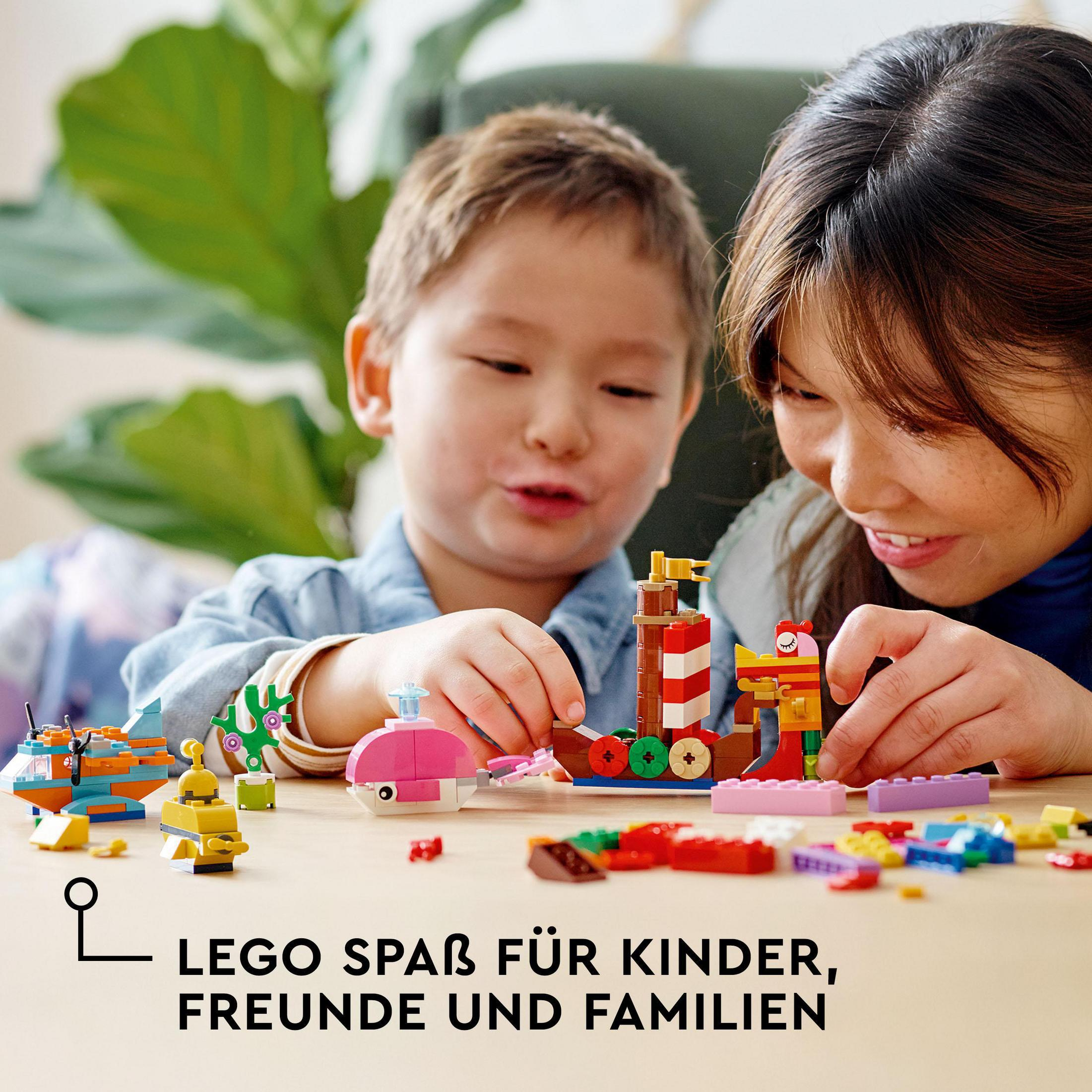 Een kind en een volwassene spelen met LEGO's. Verschillende LEGO-creaties op de tafel. De tekst zegt: LEGO plezier.