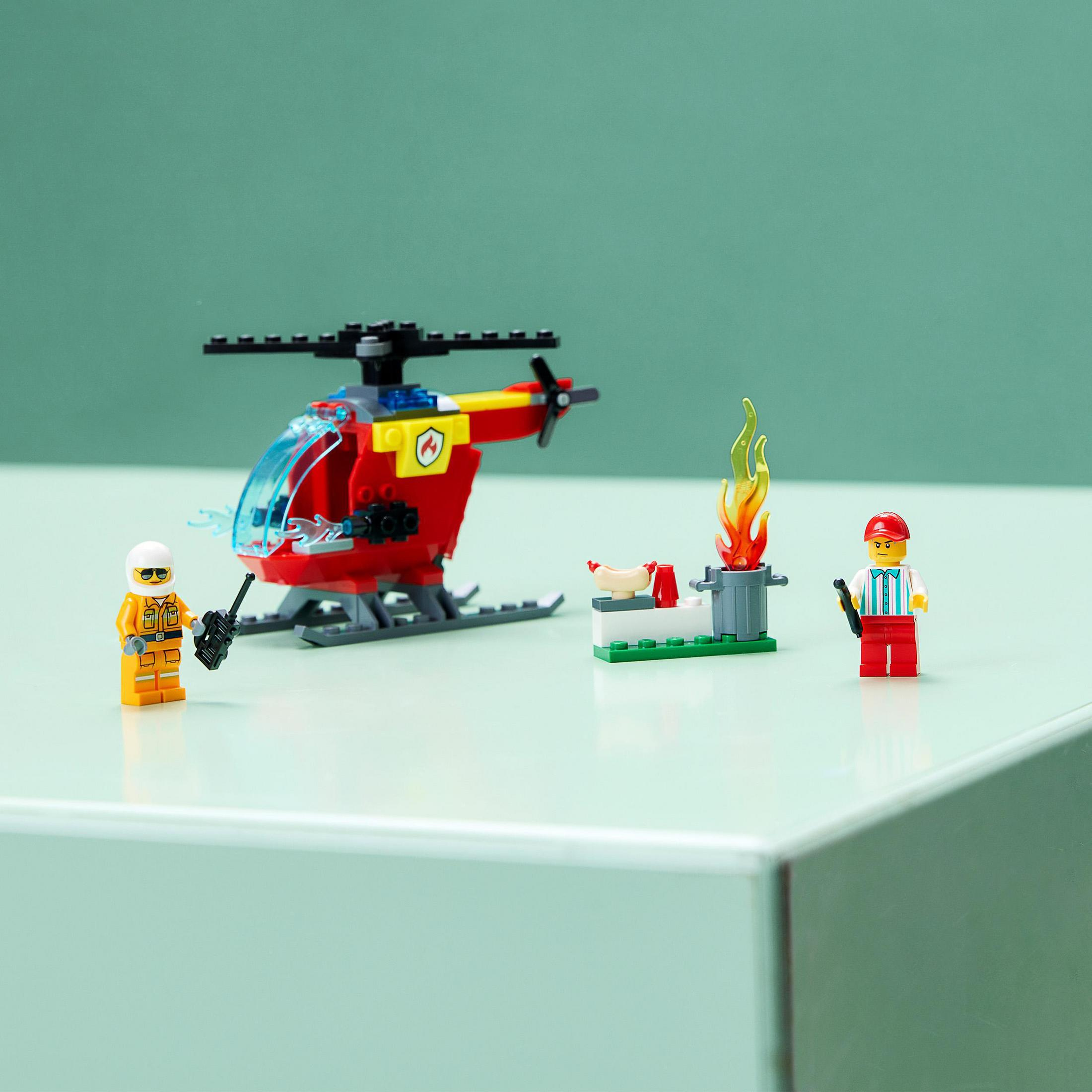 Ein Lego-Set mit einem roten Hubschrauber, einem Feuerwehrmann und einem kleinen Feuer mit Minifiguren.