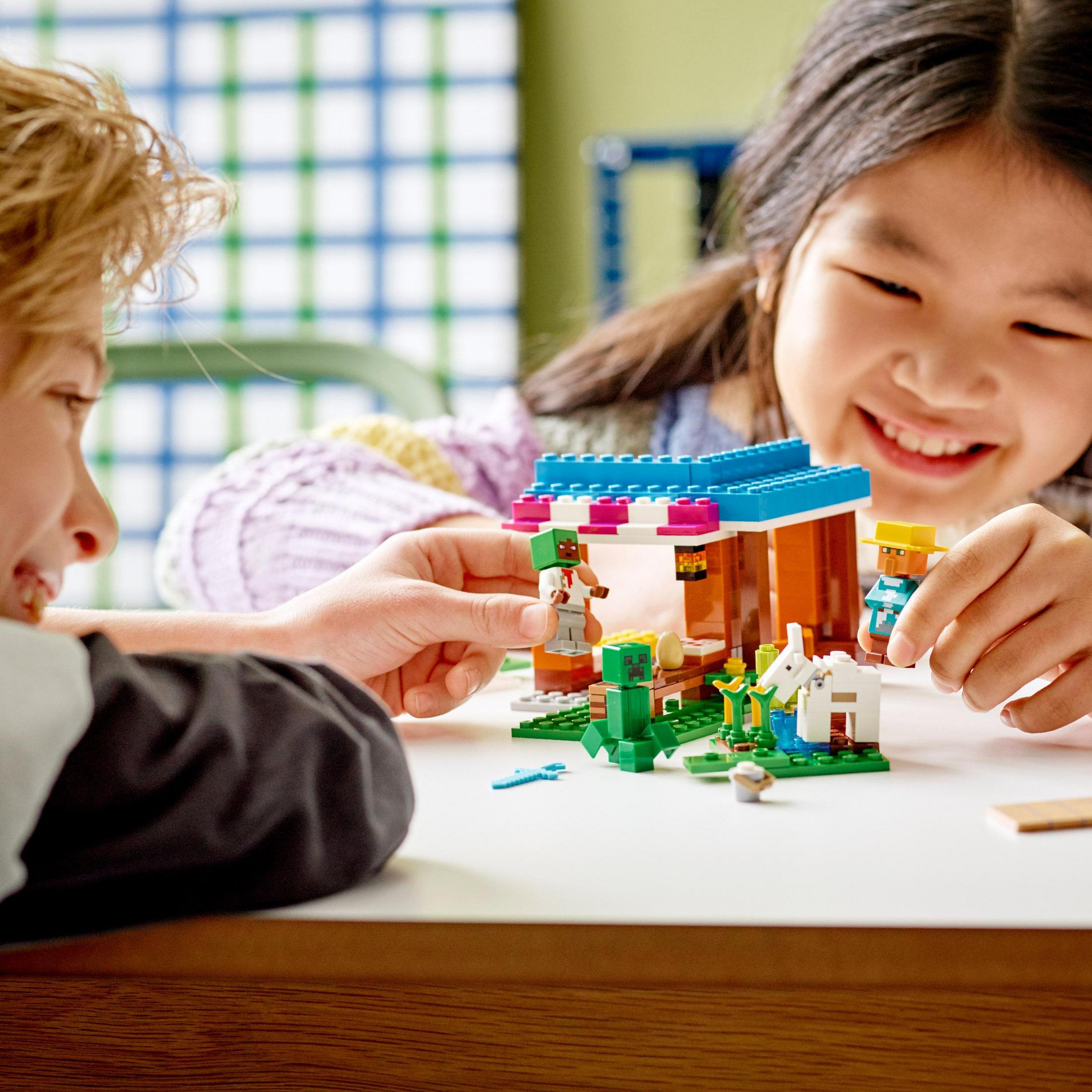 Kinder spielen mit Lego Minecraft Set. Bauen ein Haus mit Figuren.