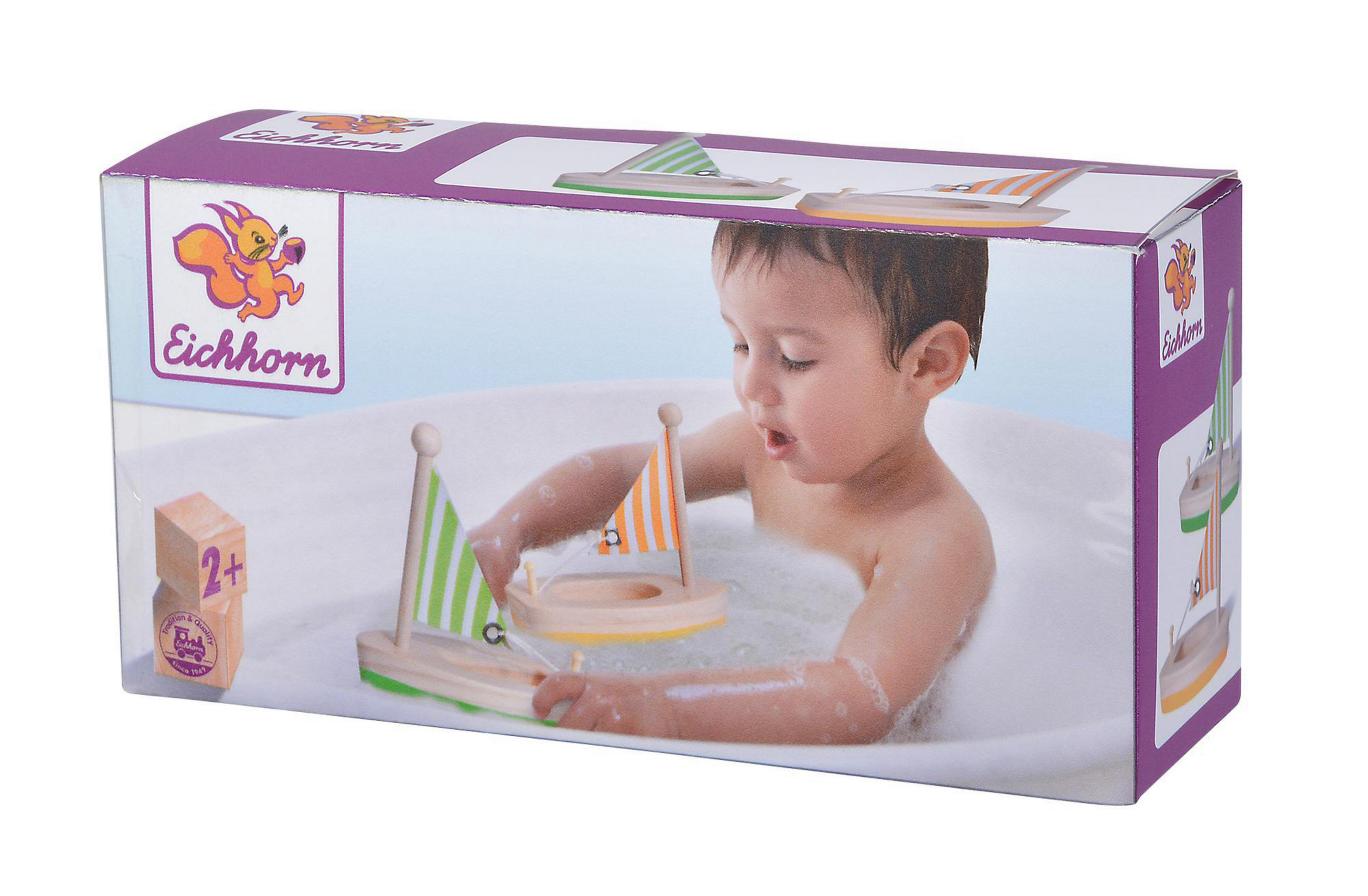 Ein Kind in einer Badewanne mit Spielzeugbooten auf einer Schachtel. Die Schachtel enthält Boote und Logo.