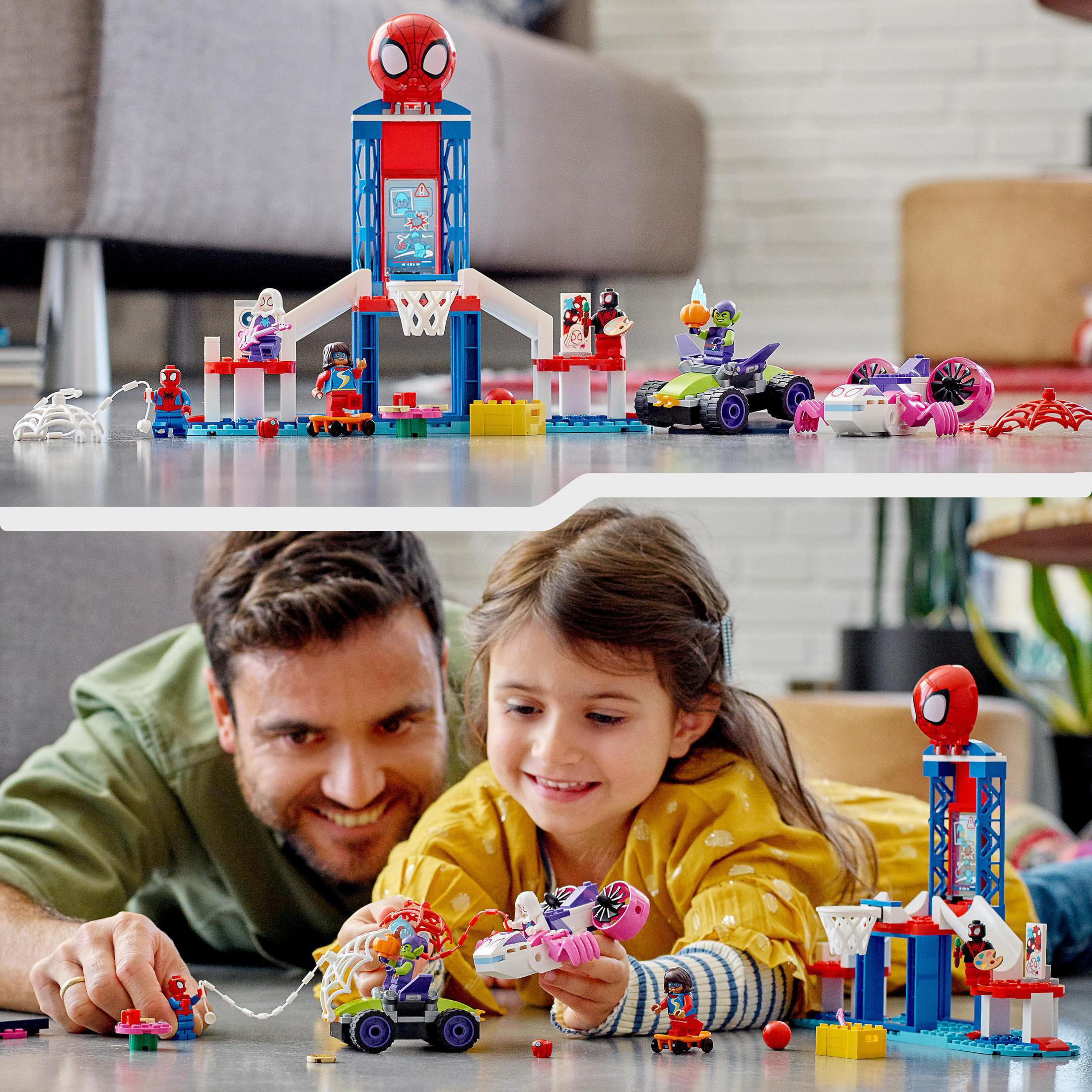 Ein Lego-Set mit Spider-Man-Figuren und verschiedenen Strukturen. Ein Mann und ein Mädchen spielen damit.