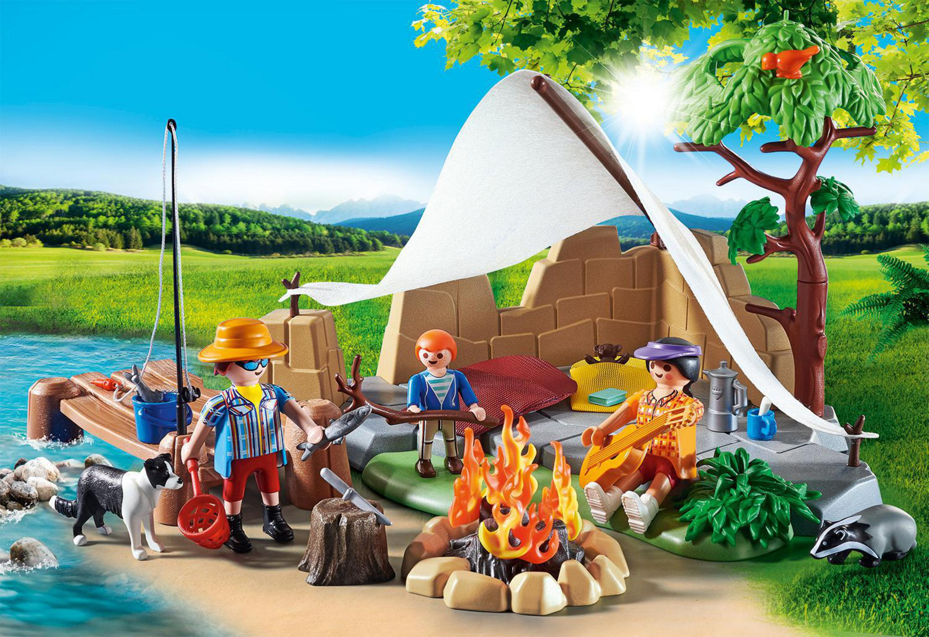 Una scena di campeggio Playmobil con personaggi, tenda, fuoco e lago in un ambiente soleggiato.