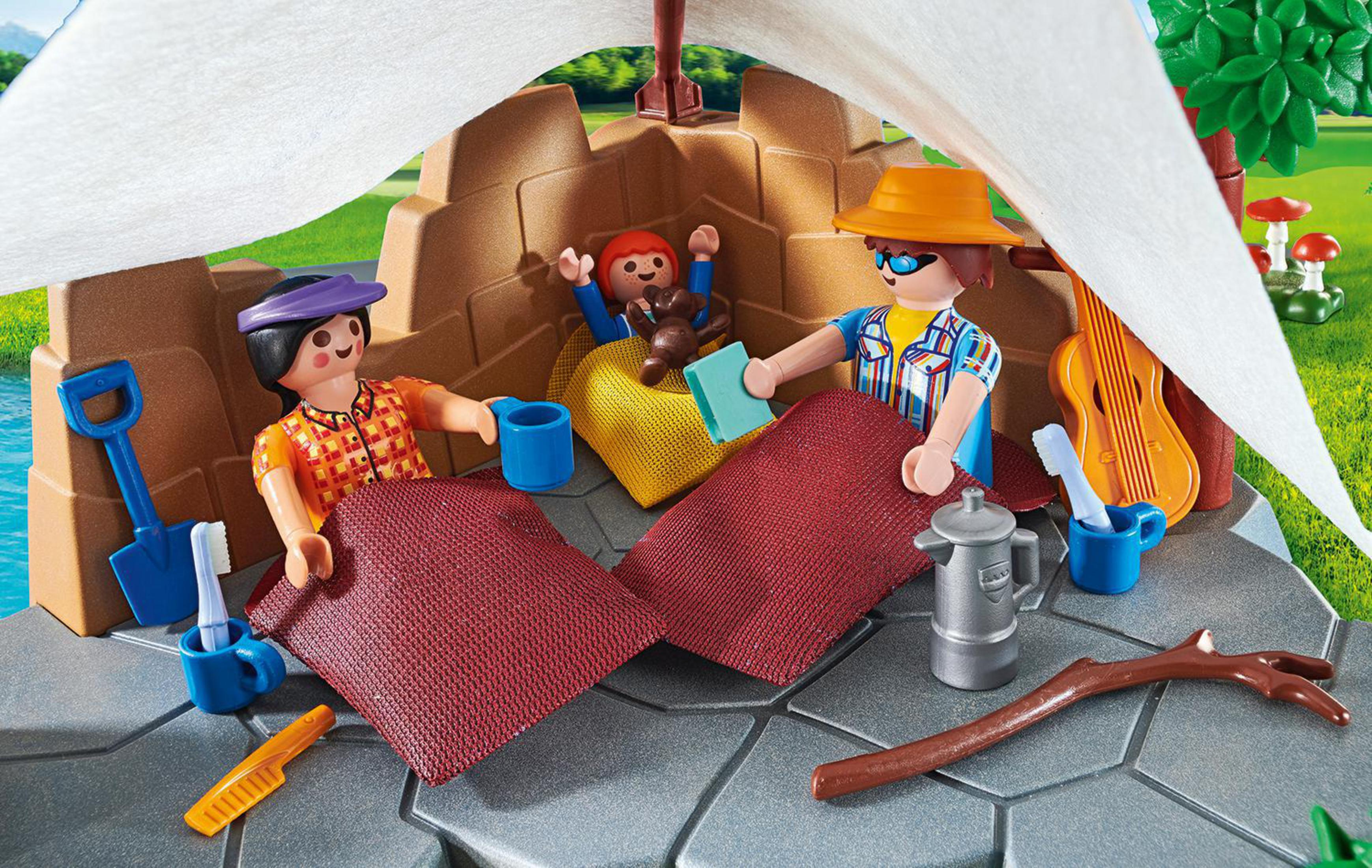 Una scena di campeggio Playmobil con personaggi, una tenda e accessori su una superficie.