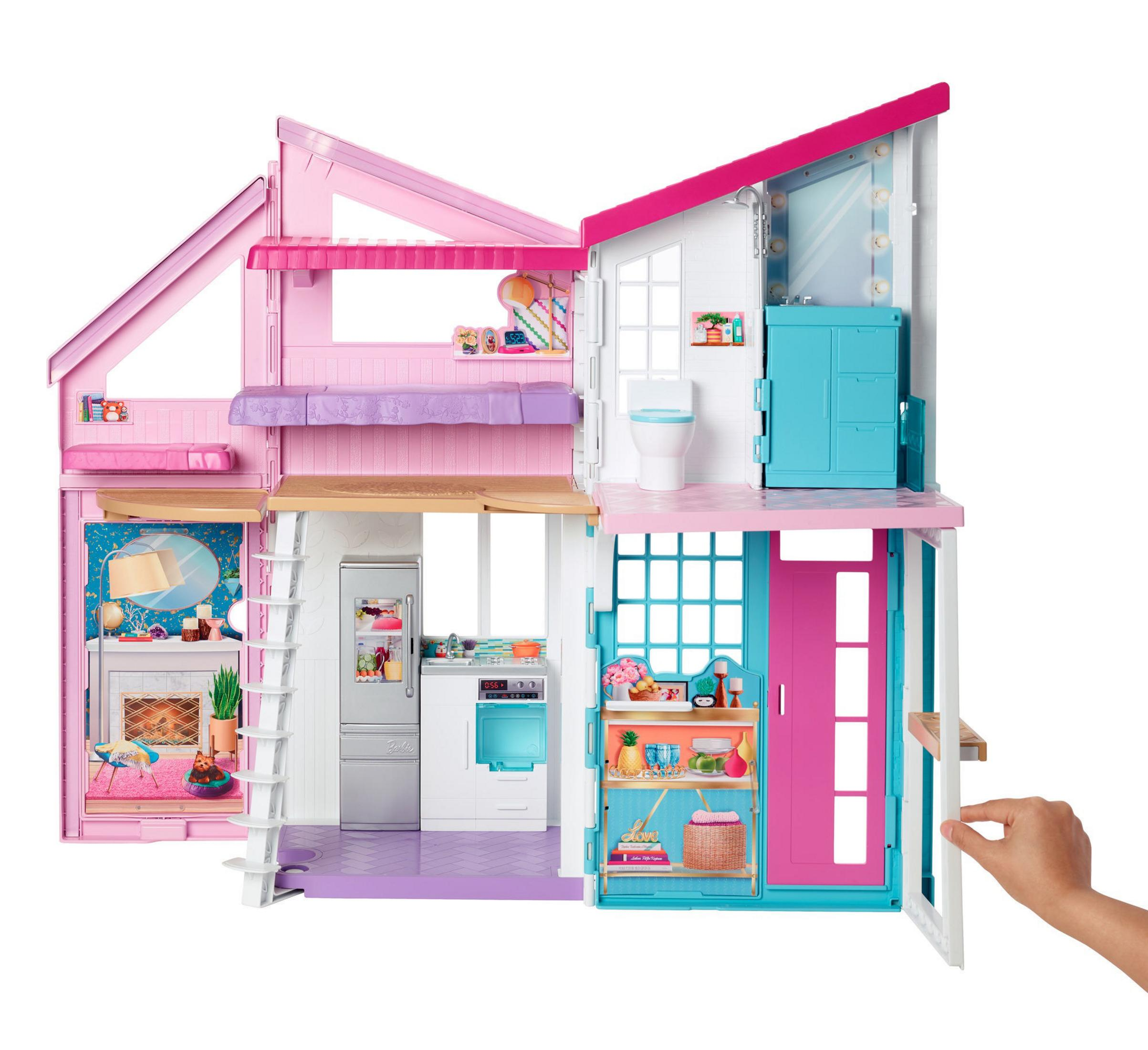 Ein Barbie Dreamhouse mit mehreren Etagen, Zimmern und Möbeln. Außenaufnahme, rosa und weiß.