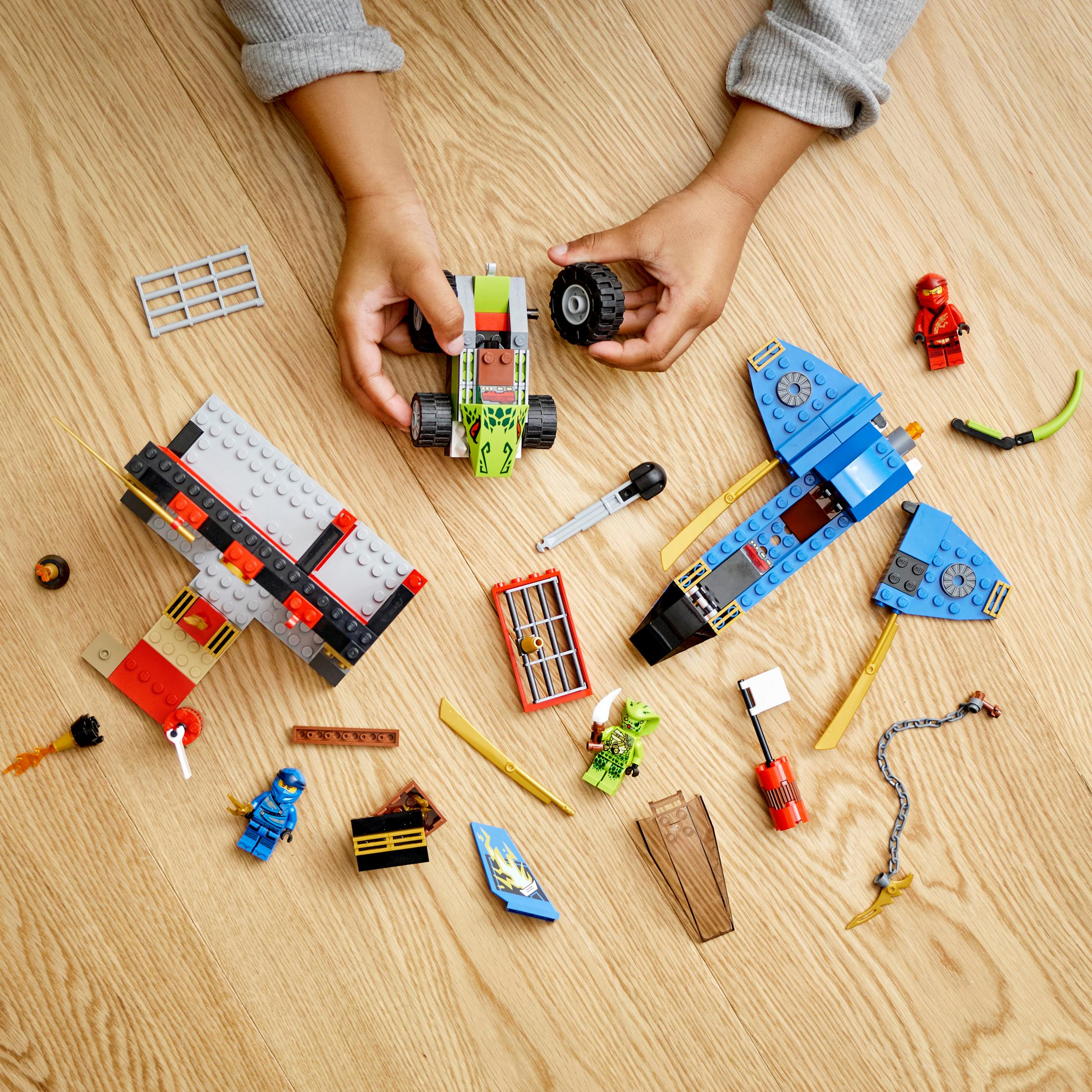 Kinderhände, die ein LEGO Ninjago-Set zusammenbauen. Verschiedene LEGO-Teile sind auf einer Holzoberfläche verstreut.