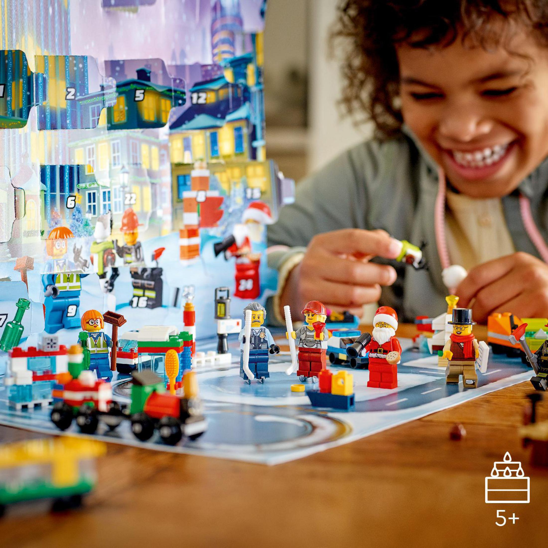 Ein Junge lächelt, während er mit einem Lego-Set spielt. Verschiedene Lego-Figuren sind dabei.