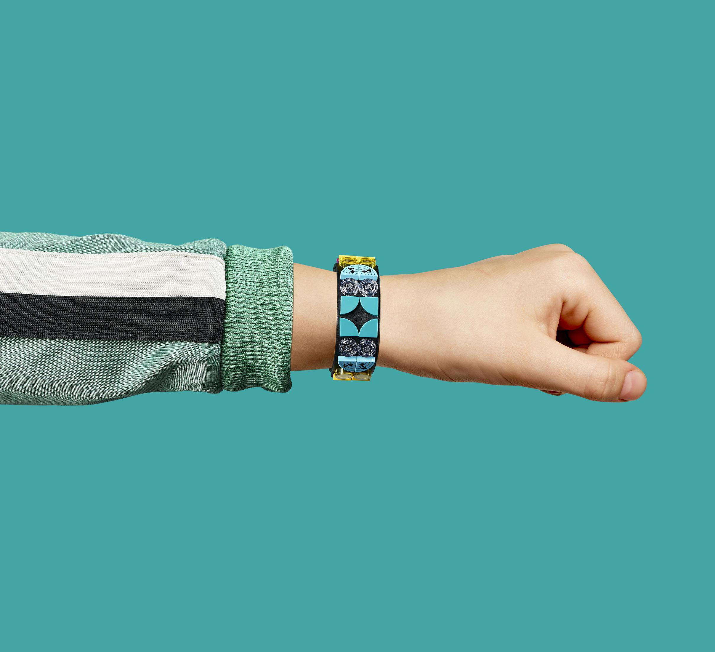 Nadgarstek osoby z kolorową bransoletką LEGO. Bransoletka jest niebieska i czarna.