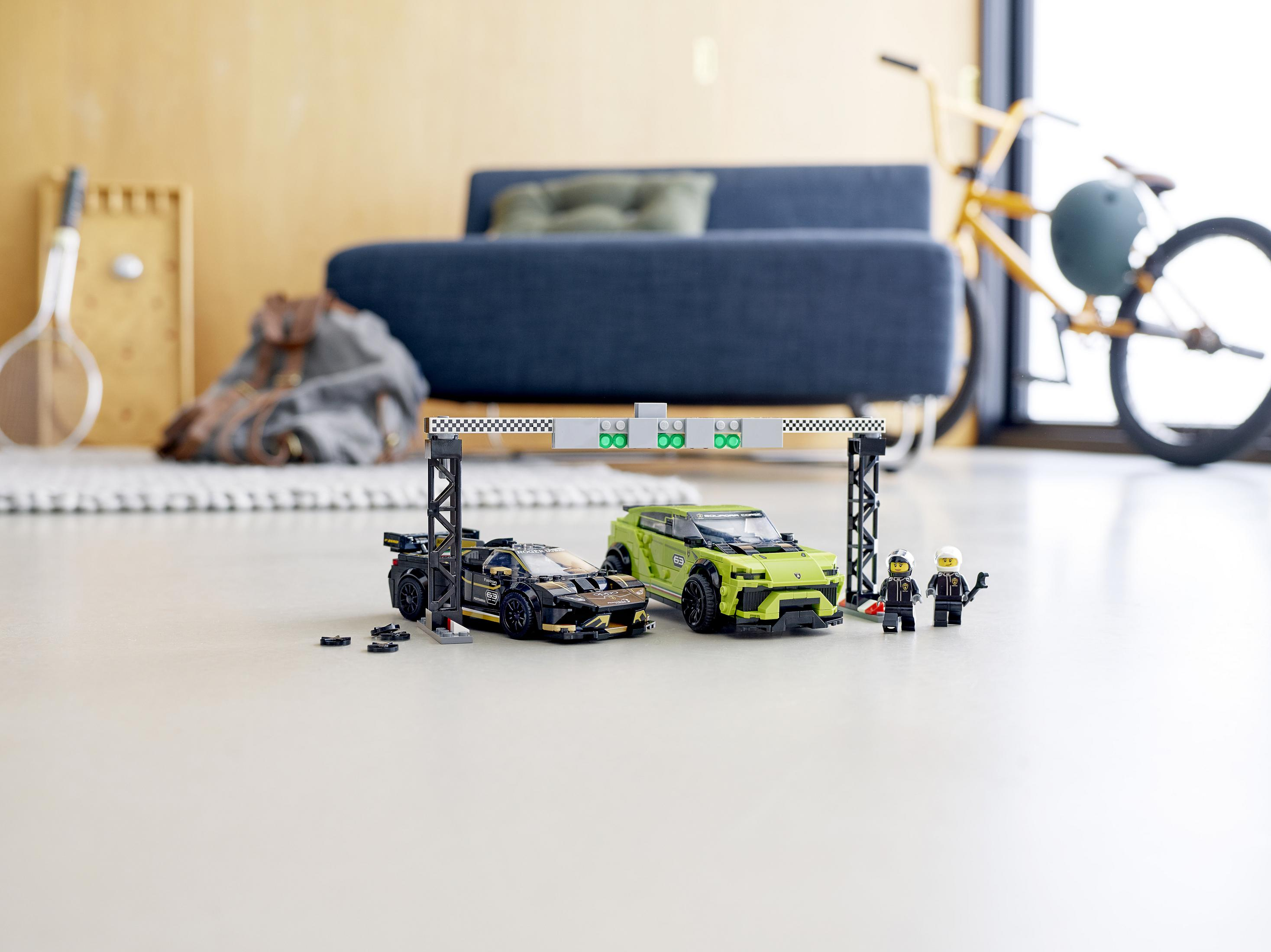 Lego race cars and figures at a starting line with a sofa and a bike.