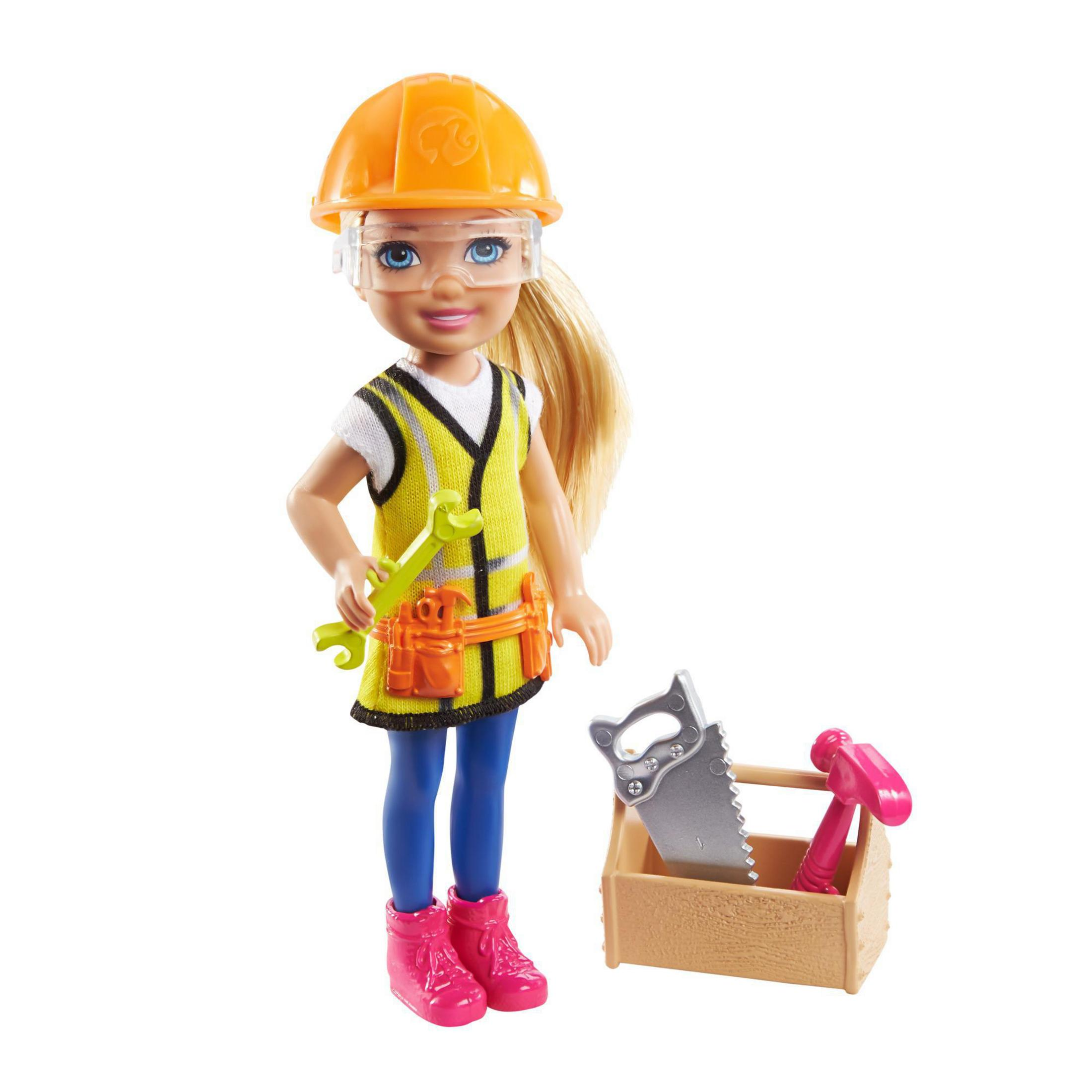 Puppe mit Bauarbeiter-Outfit. Sie trägt eine gelbe Weste, einen Helm und hält Werkzeuge. Werkzeugkasten zu ihren Füßen.