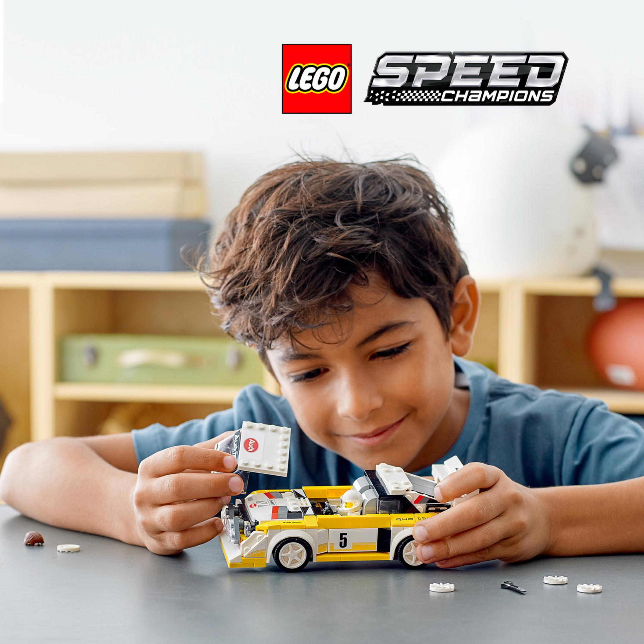 Ein Junge baut ein Lego-Auto. Die Szene spielt vor einem Regal.