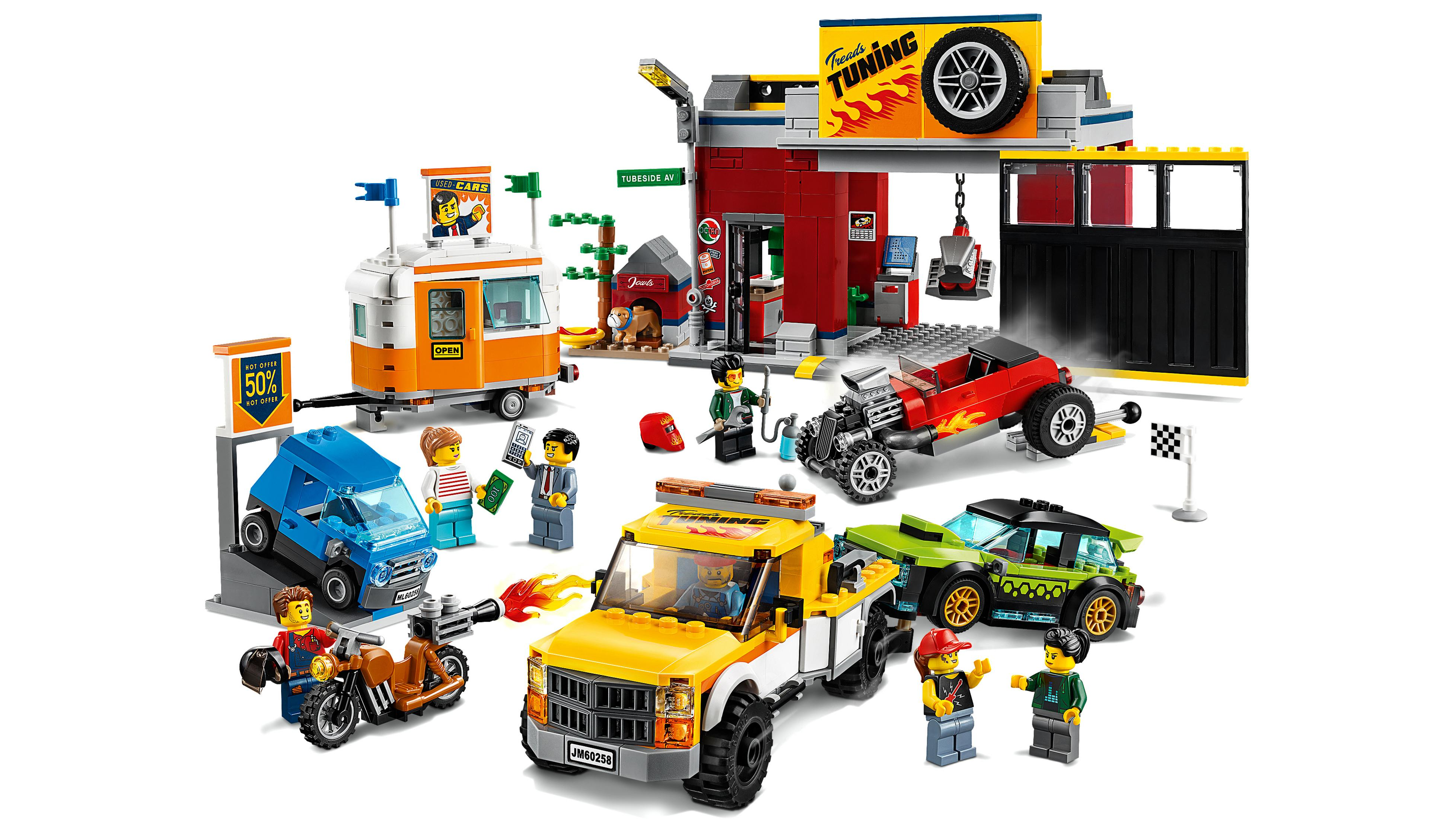 Zestaw Lego City z warsztatem samochodowym, samochodami, figurkami i lawetą.