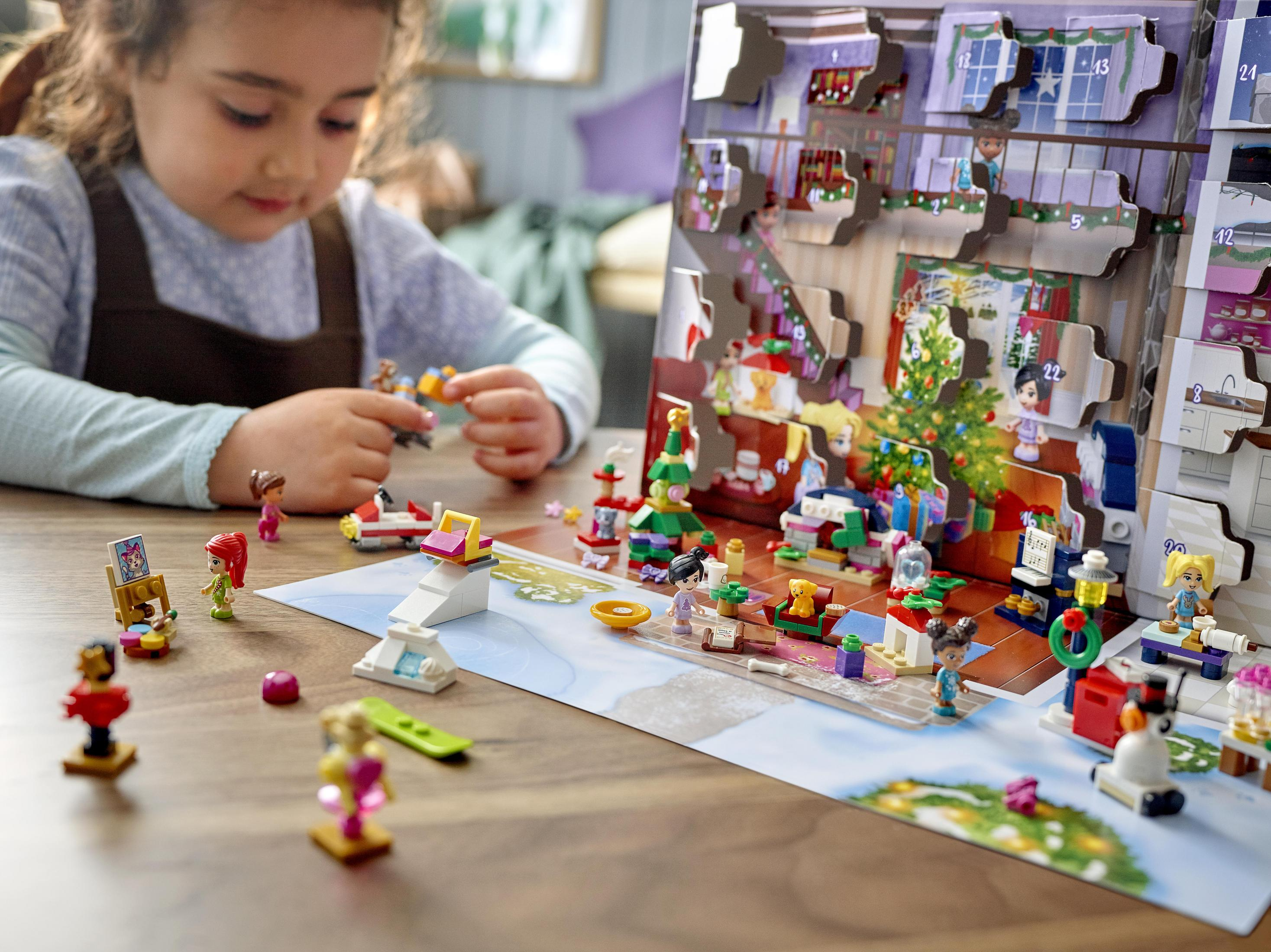 A child playing with Lego Christmas set with a decorated tree.