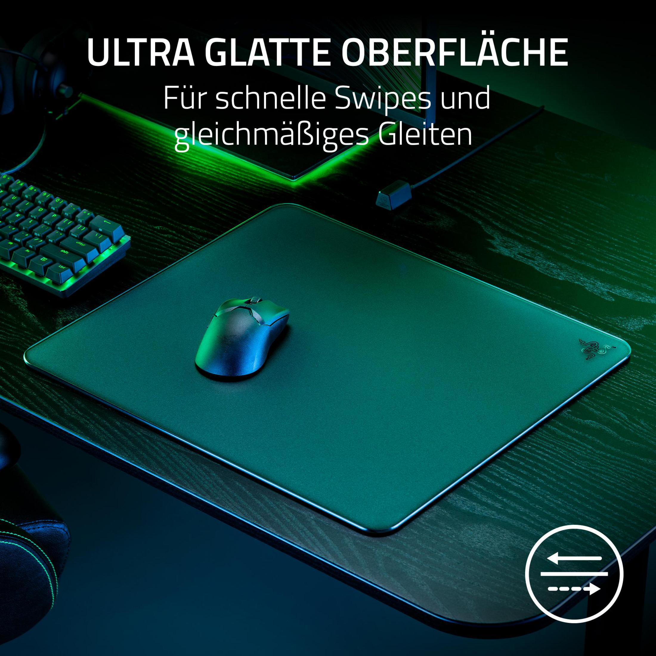 Czarna podkładka pod mysz z myszą na ciemnej powierzchni. Tekst: 'Ultra Glatte Oberfläche'.
