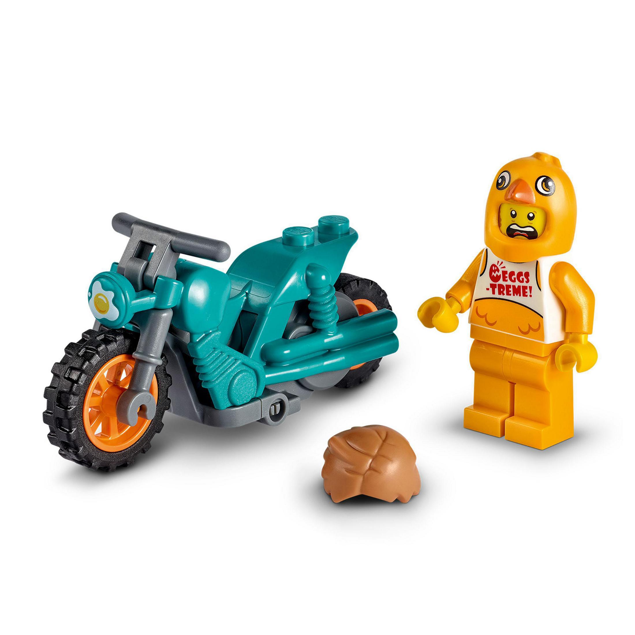 Lego-Figur im Hühnerkostüm neben einem türkisblauen Motorrad und einem braunen Hut.