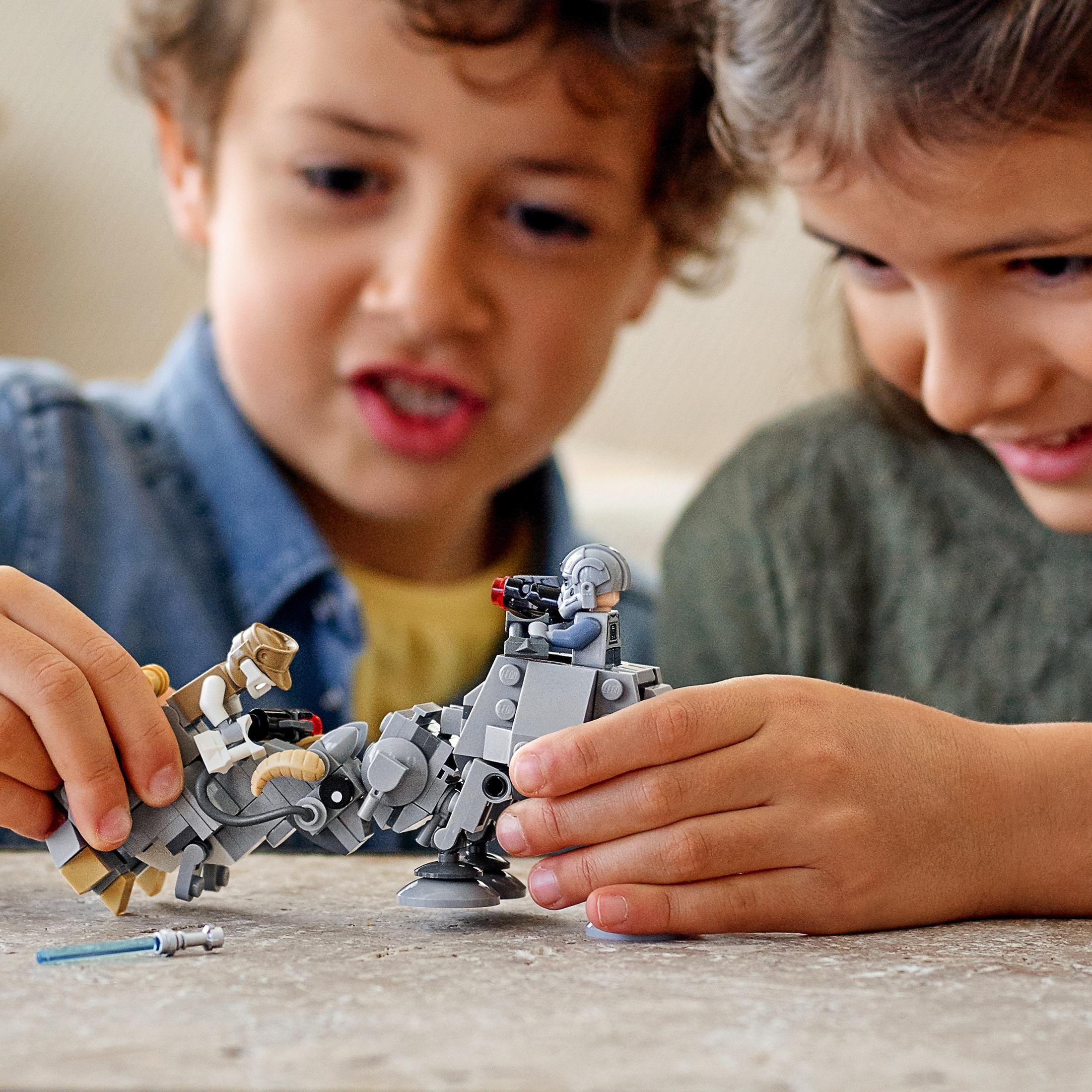 Zwei Kinder spielen mit Lego-Robotern. Einer hält eine Waffe.